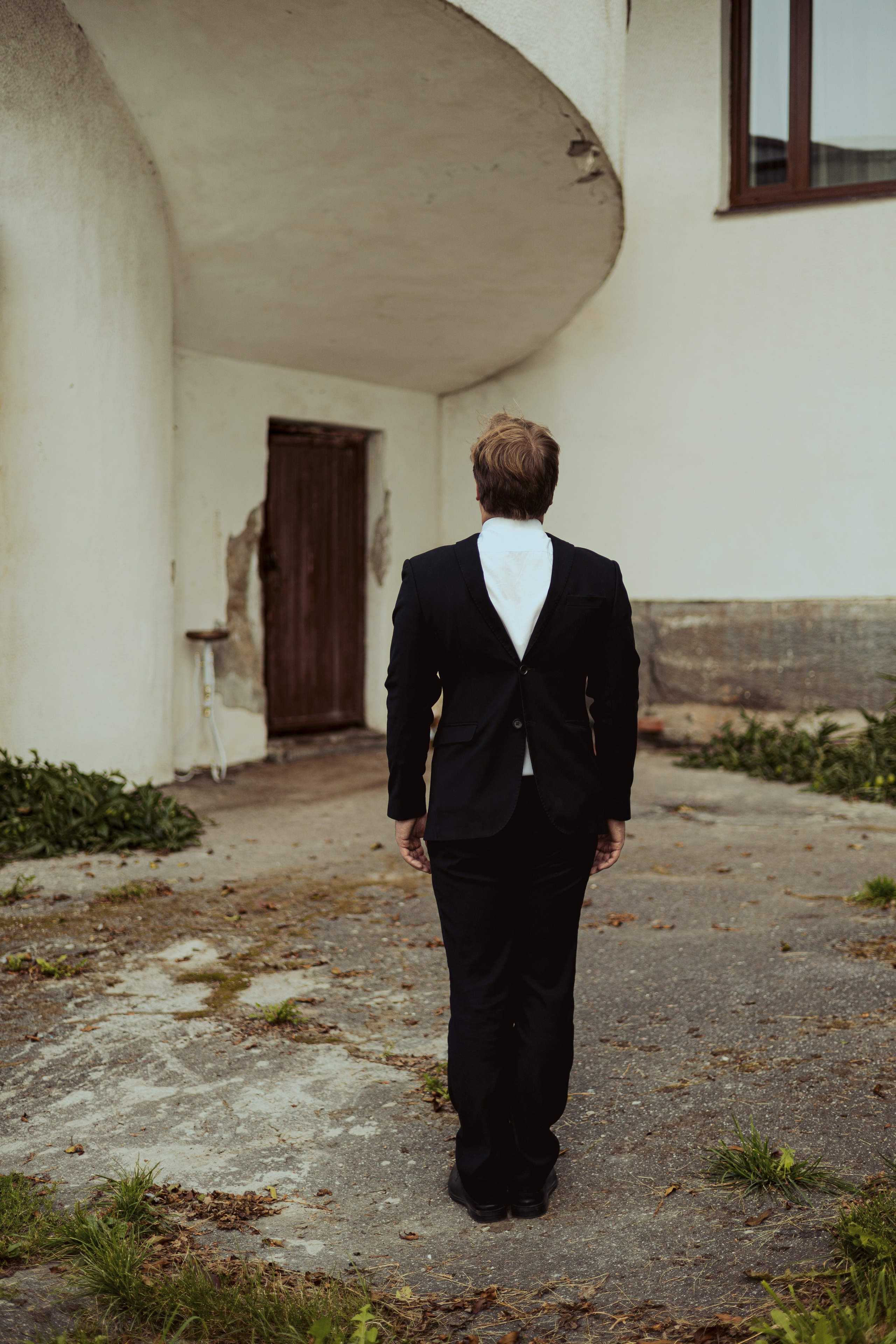 Молодой человек стоит в костюме наоборот