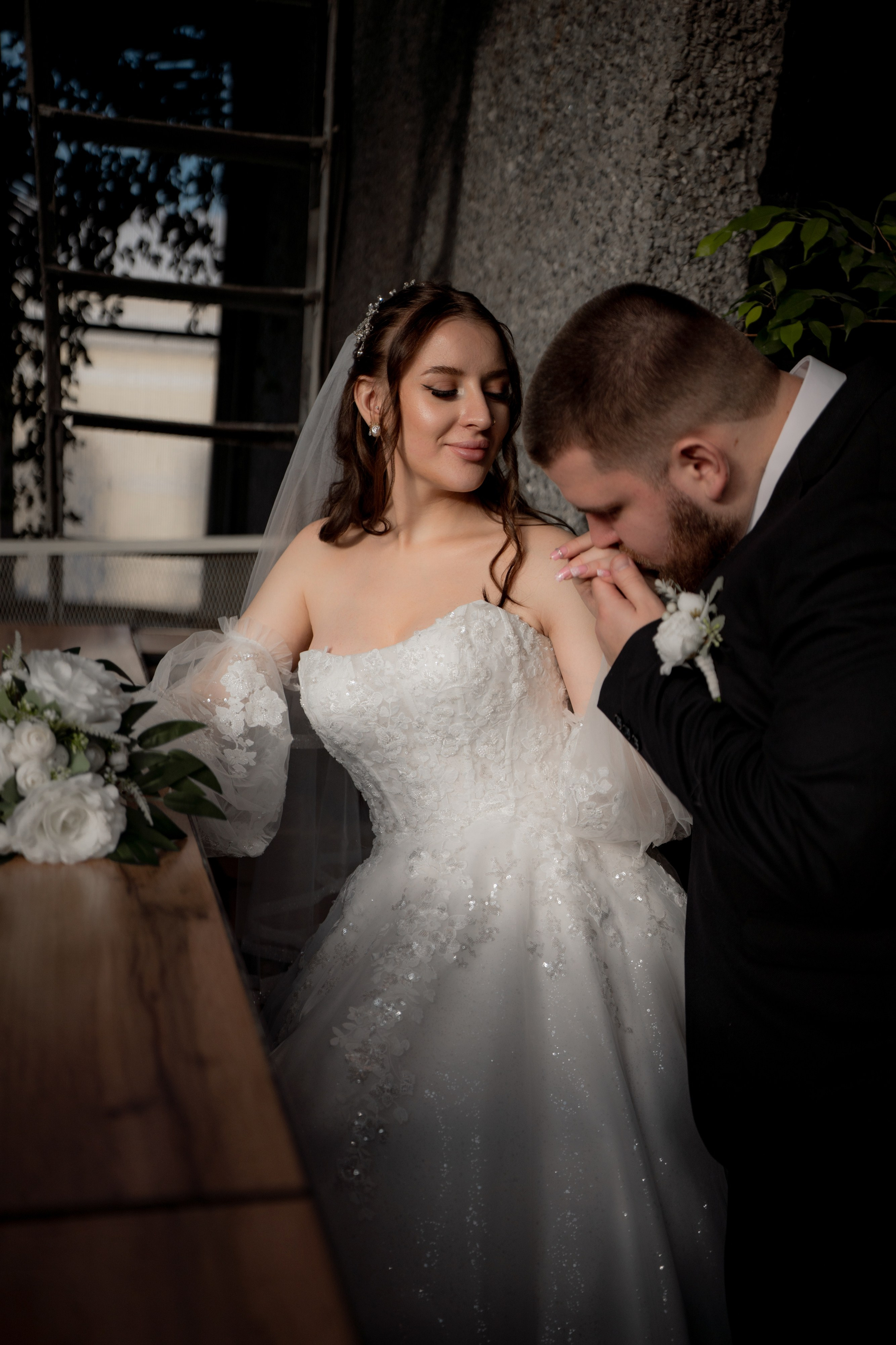 Свадебная фотография в Оранжерее Таврического сада Санкт-Петербурге. Жених Целует руку невесте. Съемка зимой