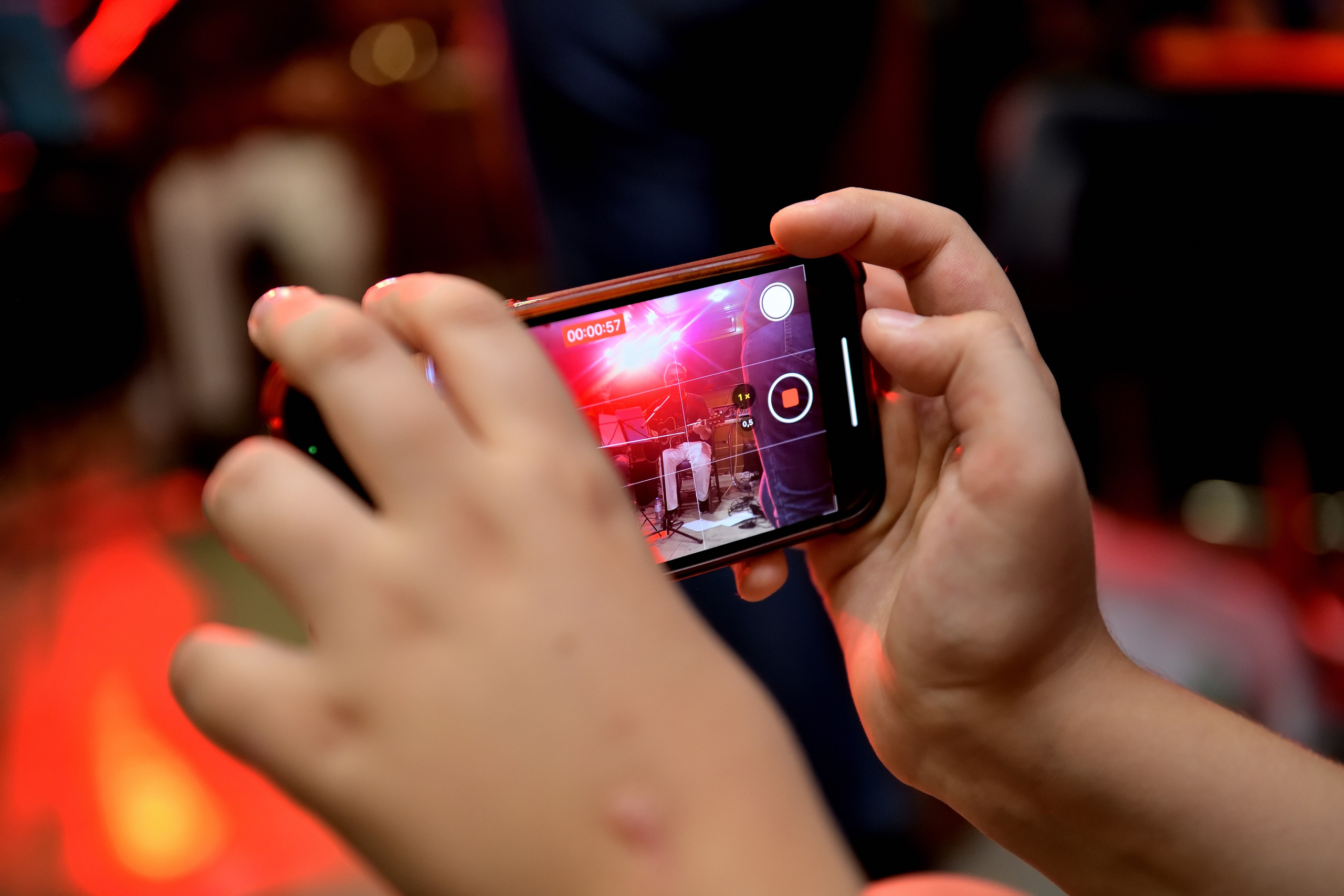 "Человек фотографирует на мобильный телефон концерт".