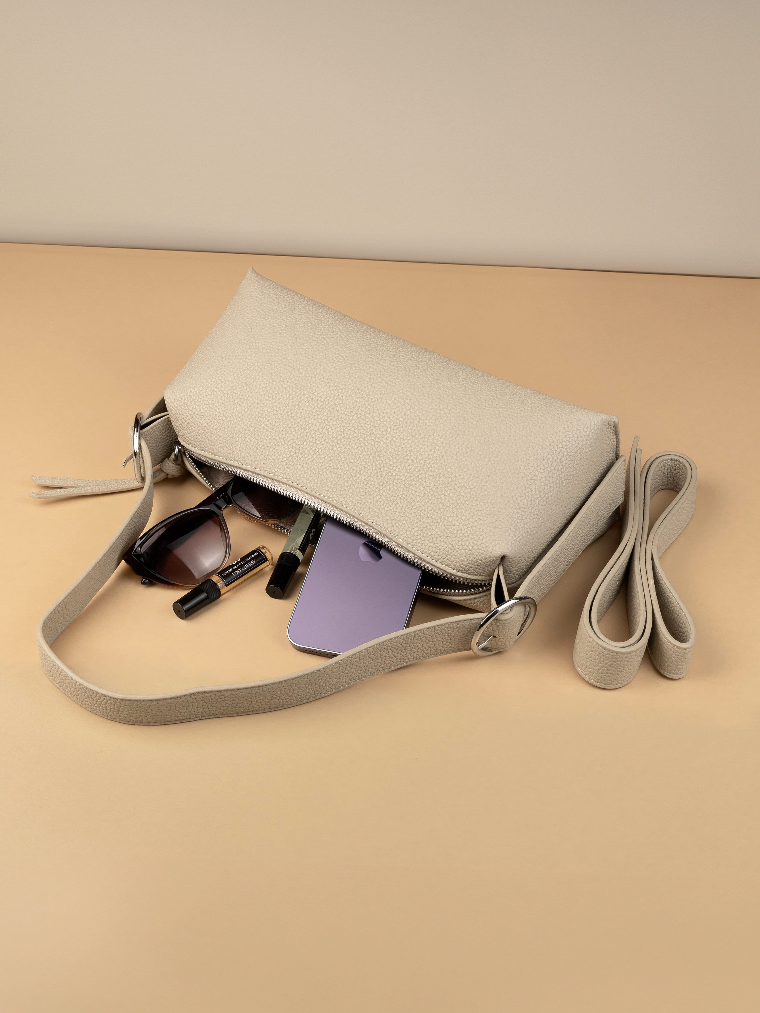 сумочка багет с предметами лежит на столе