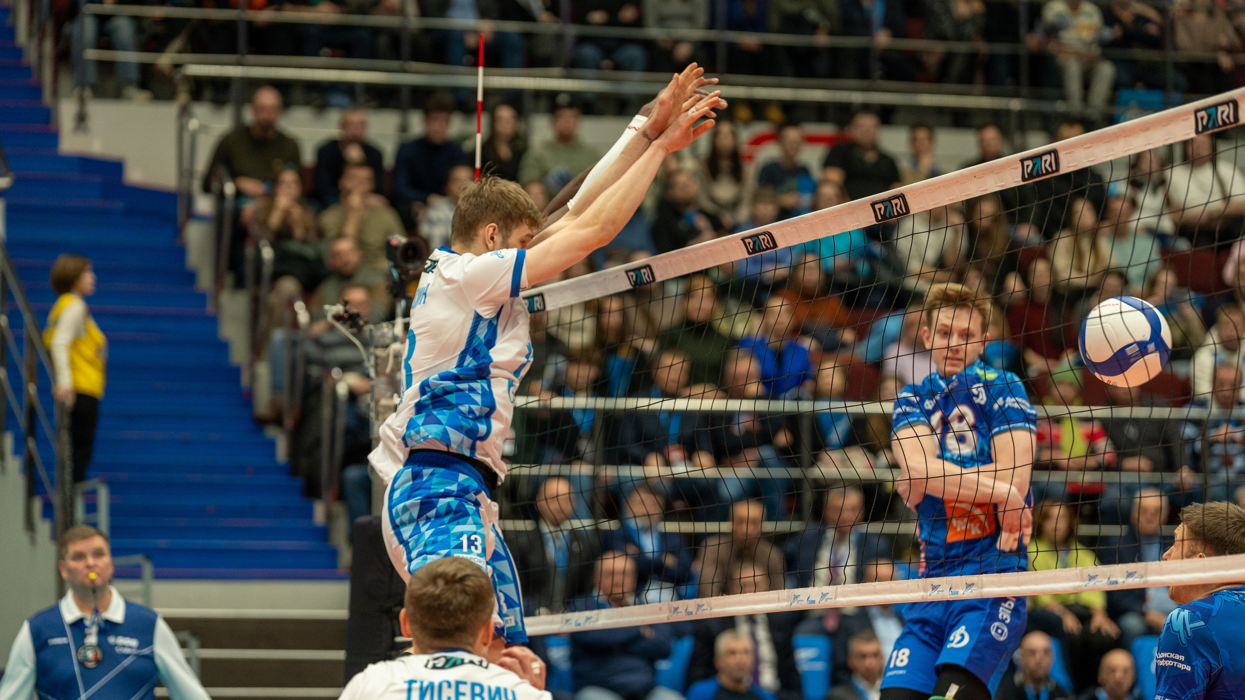 Репортажная спортивная фотосъёмка: «Зенит» СПб в прыжке на блок против «Динамо» в волейбольной битве в Санкт-Петербурге.