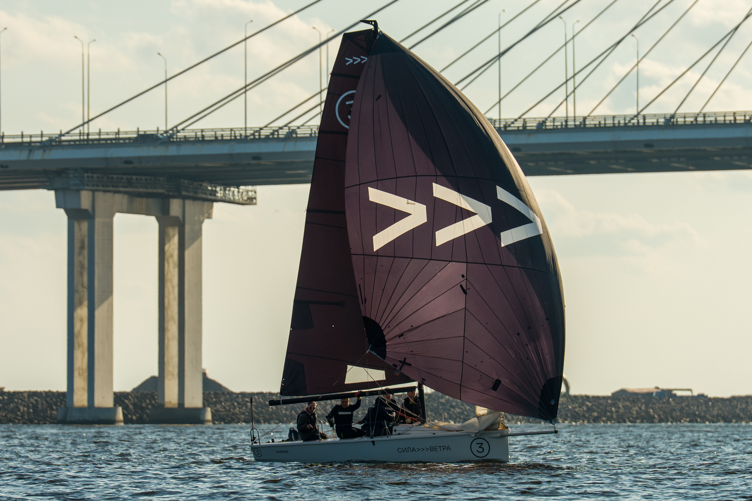 SV20 crew flies a spinnaker near the bridge, holding steady course