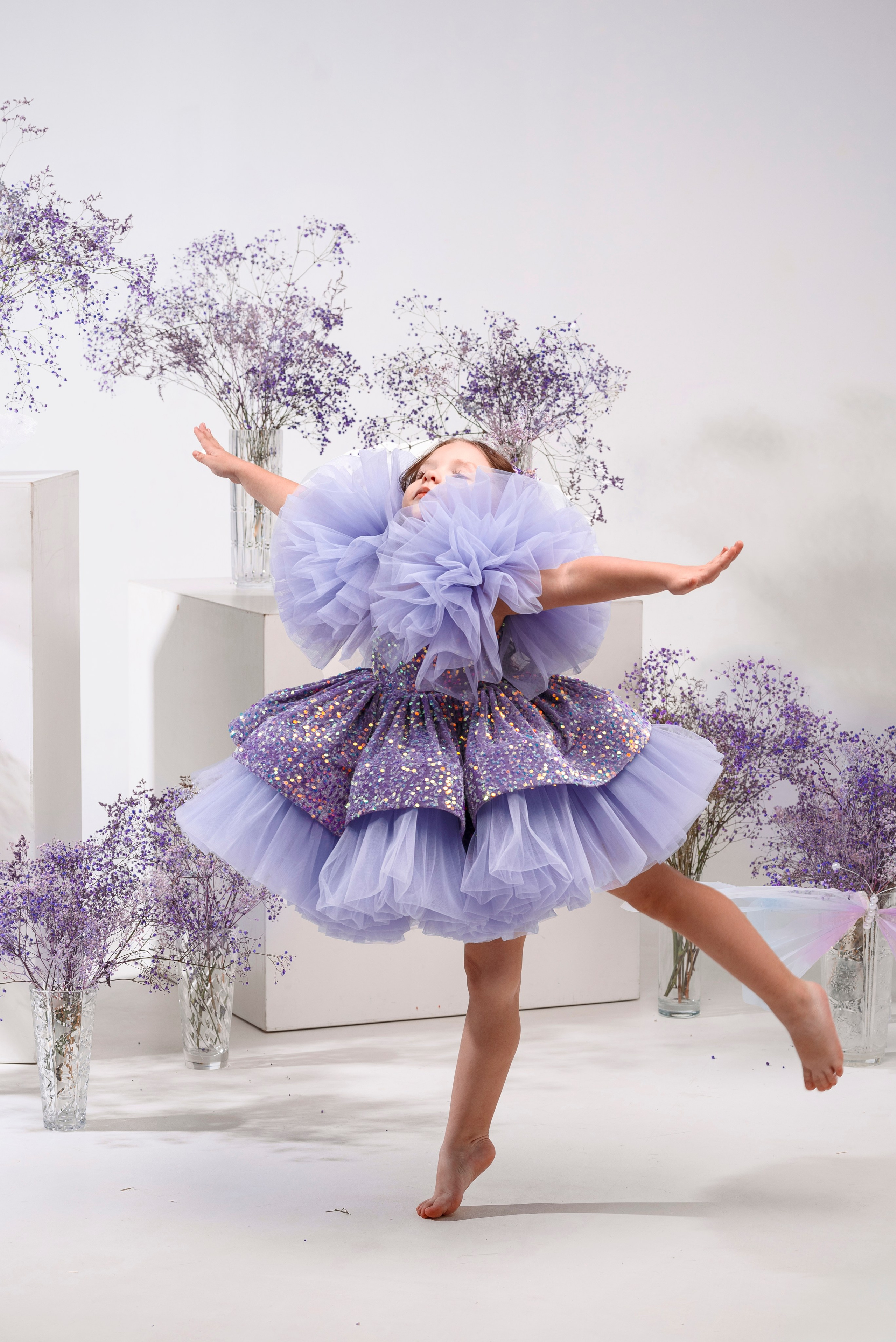 девочка в фиолетовом платье в фотостудии с гипсофилой