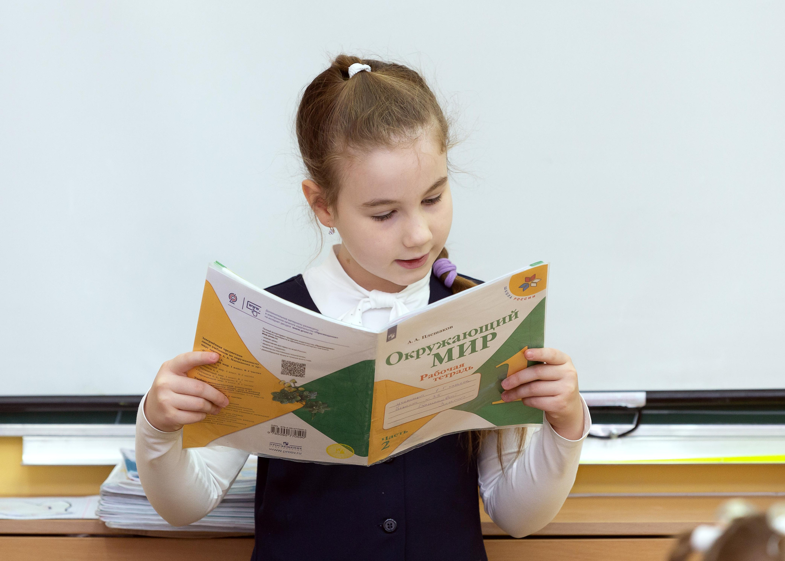 Девочка держит учебник