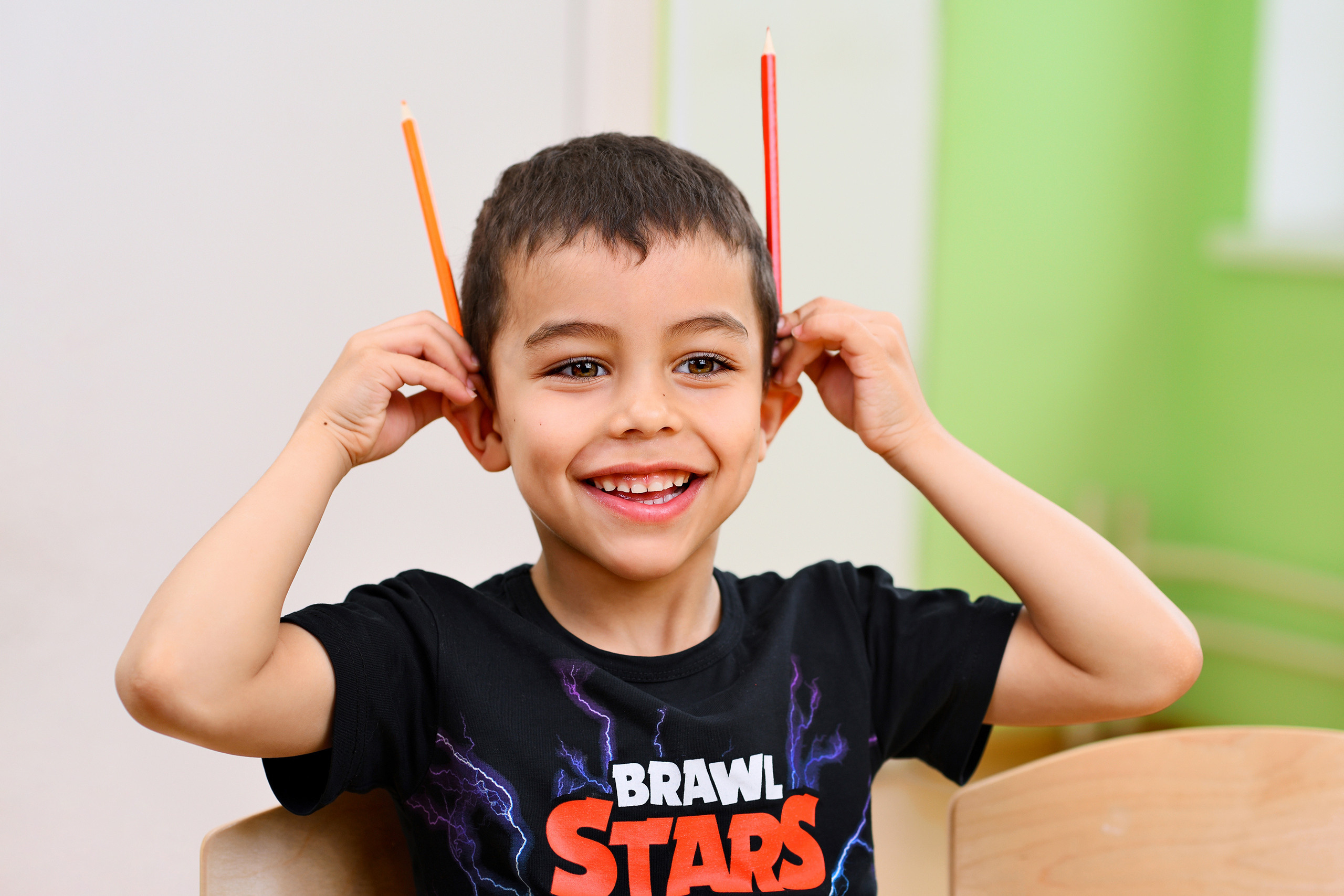 Мальчик в детском саду делает рожки из карандашей.