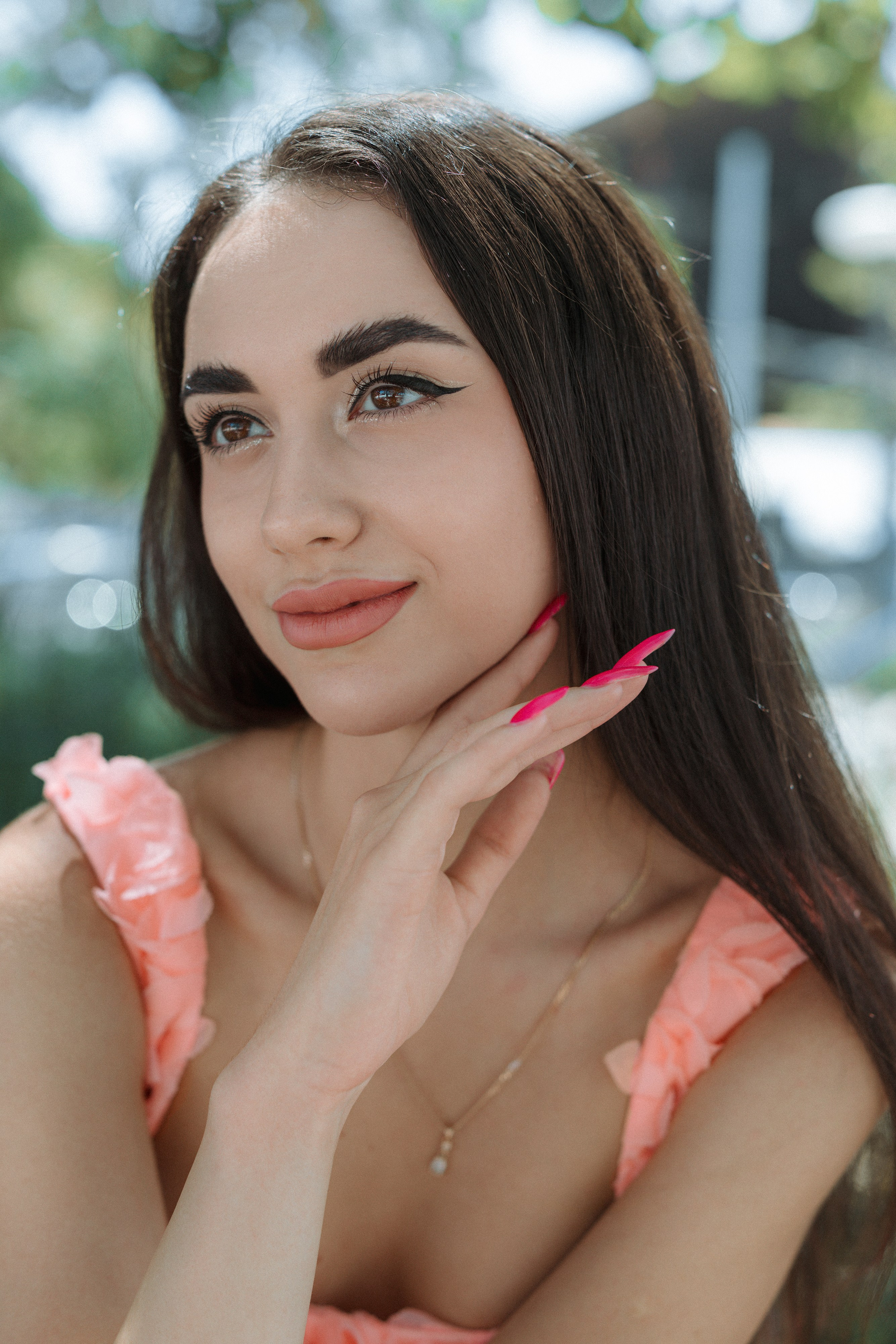 Elegant girl in pastel attire leaning against a historic building in Barcelona.
