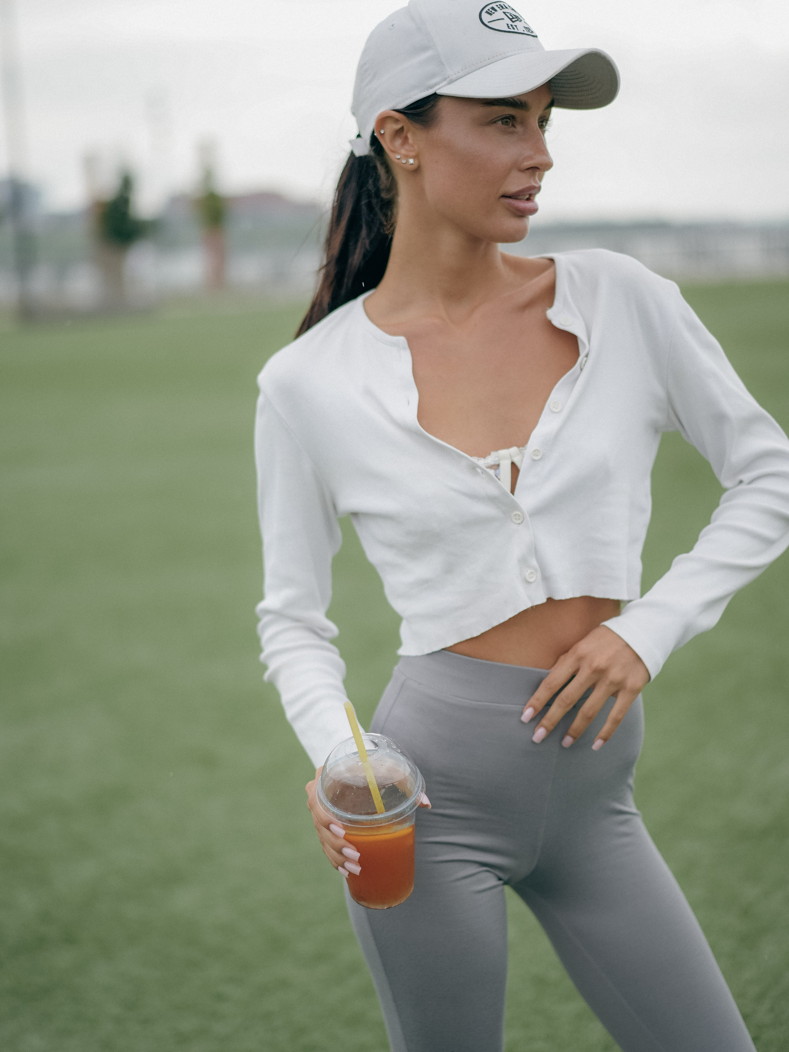 Стильная девушка в образе спорт-шик на стадионе