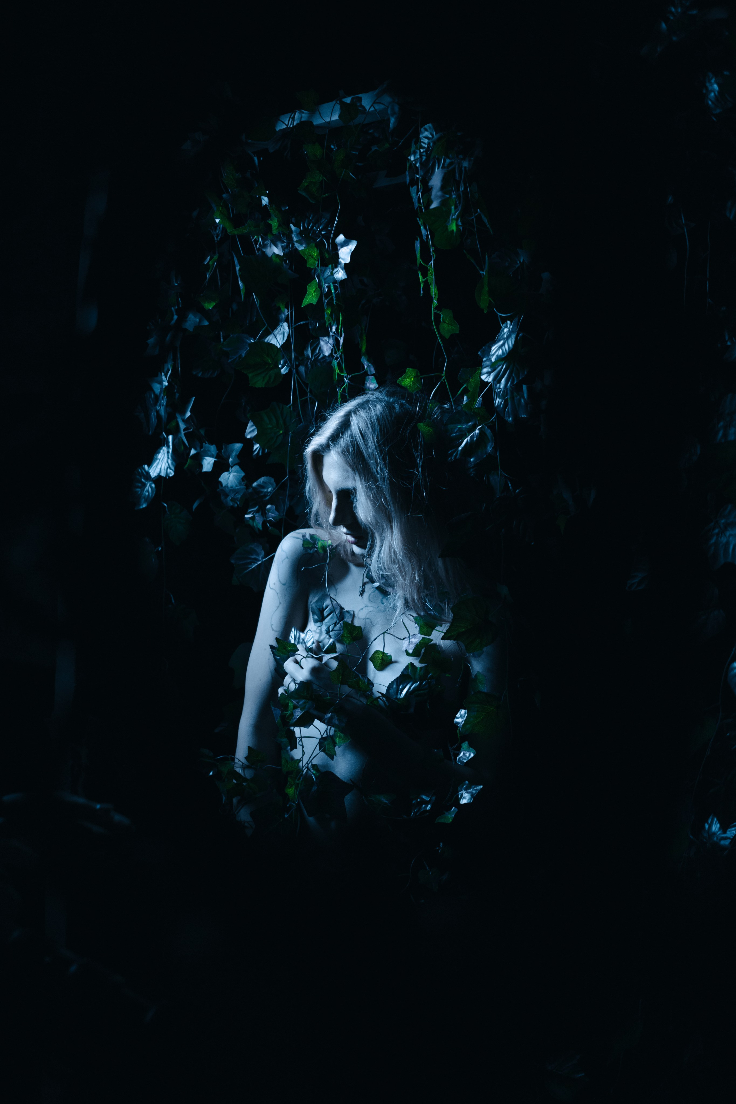 Художественная фотосессия в фотостудии во Владивостоке, девушка опутанная плющом печально смотрит вниз