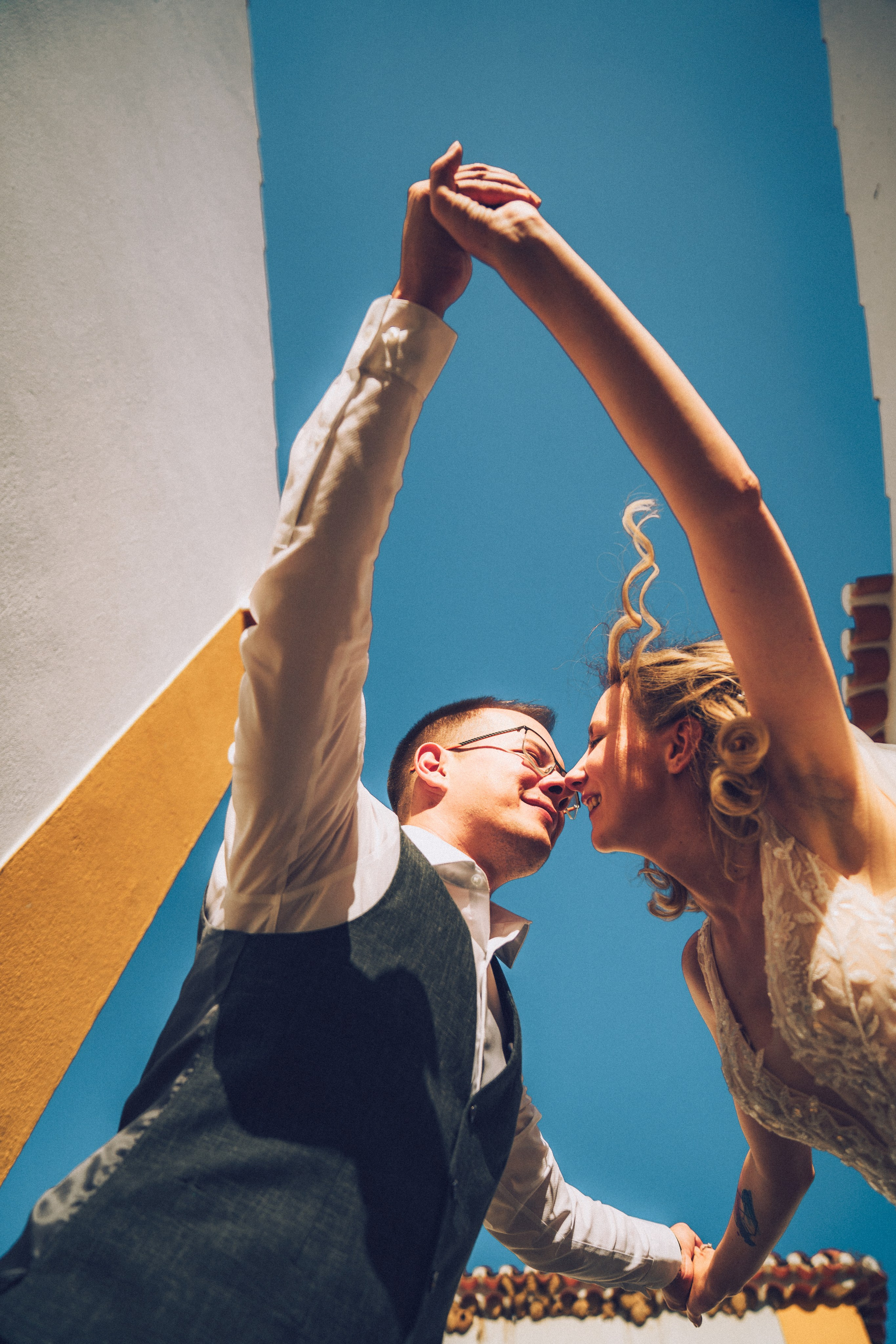 Влюбленная  пара жених и невеста целуется и обнимаются на фоне старинных улочек Португалии