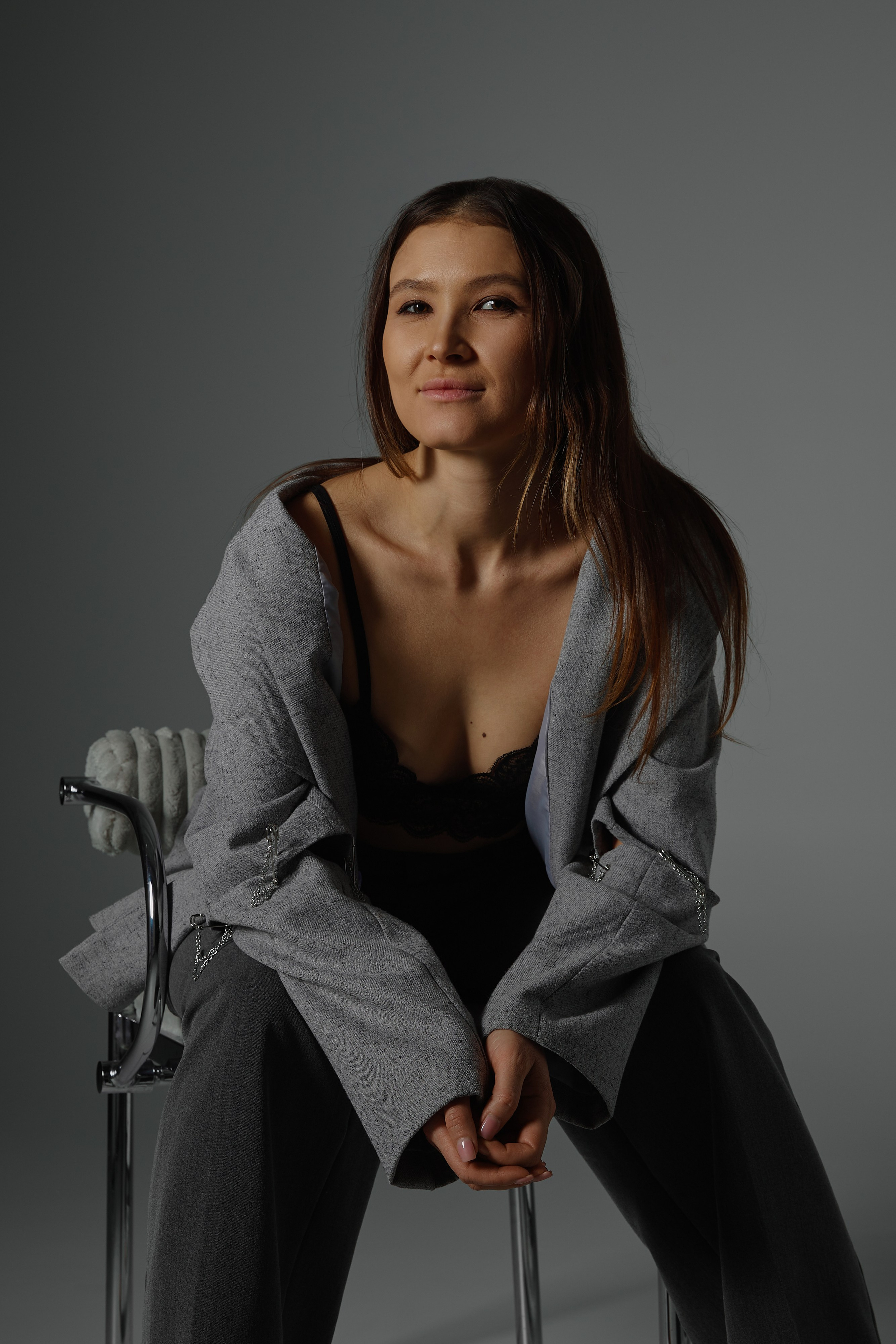 Фотосессия девушка сидит на стуле в фотостудии