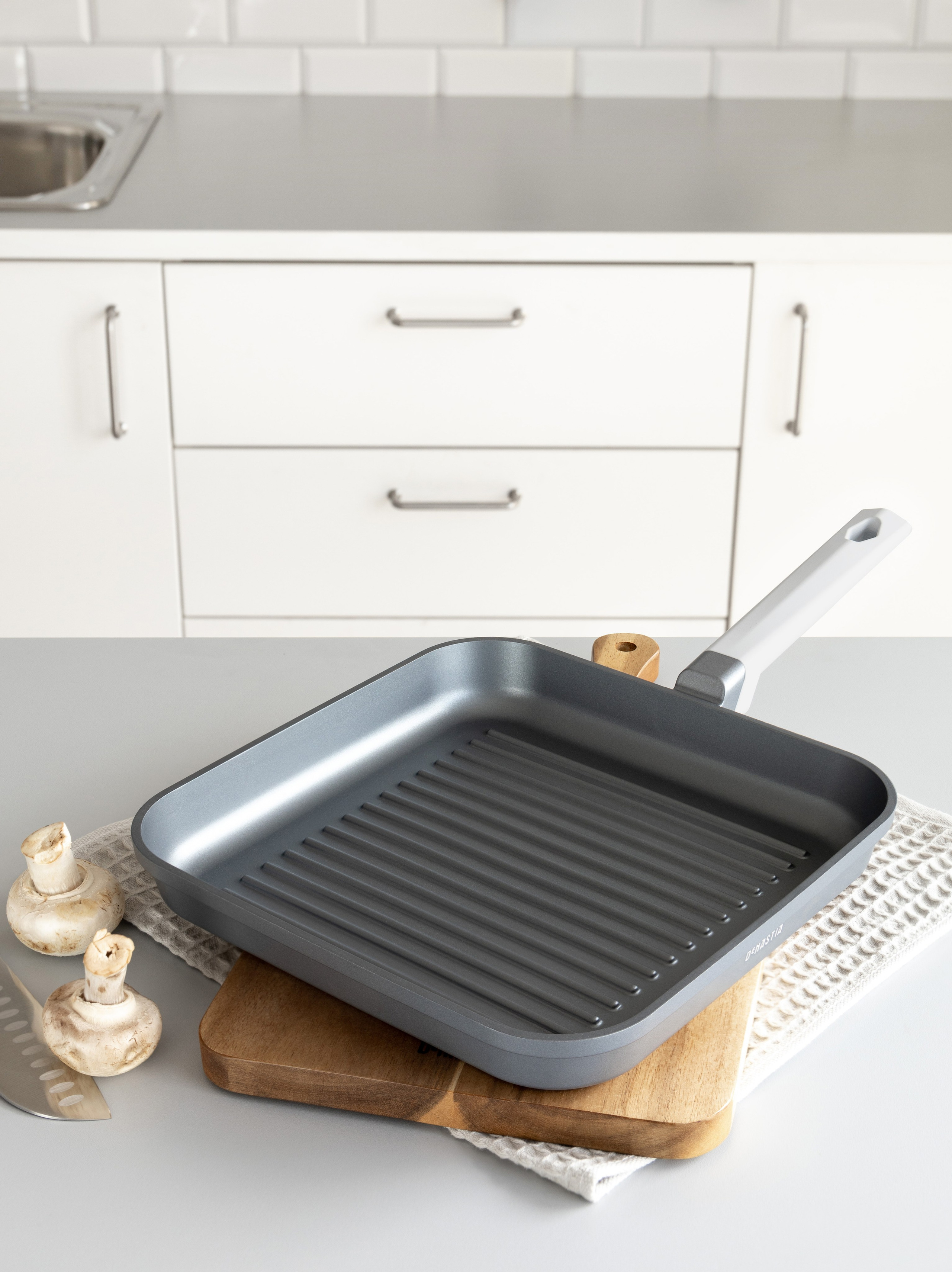 Сковорода-гриль на фоне кухонного фартука и мебели | Фото для каталога