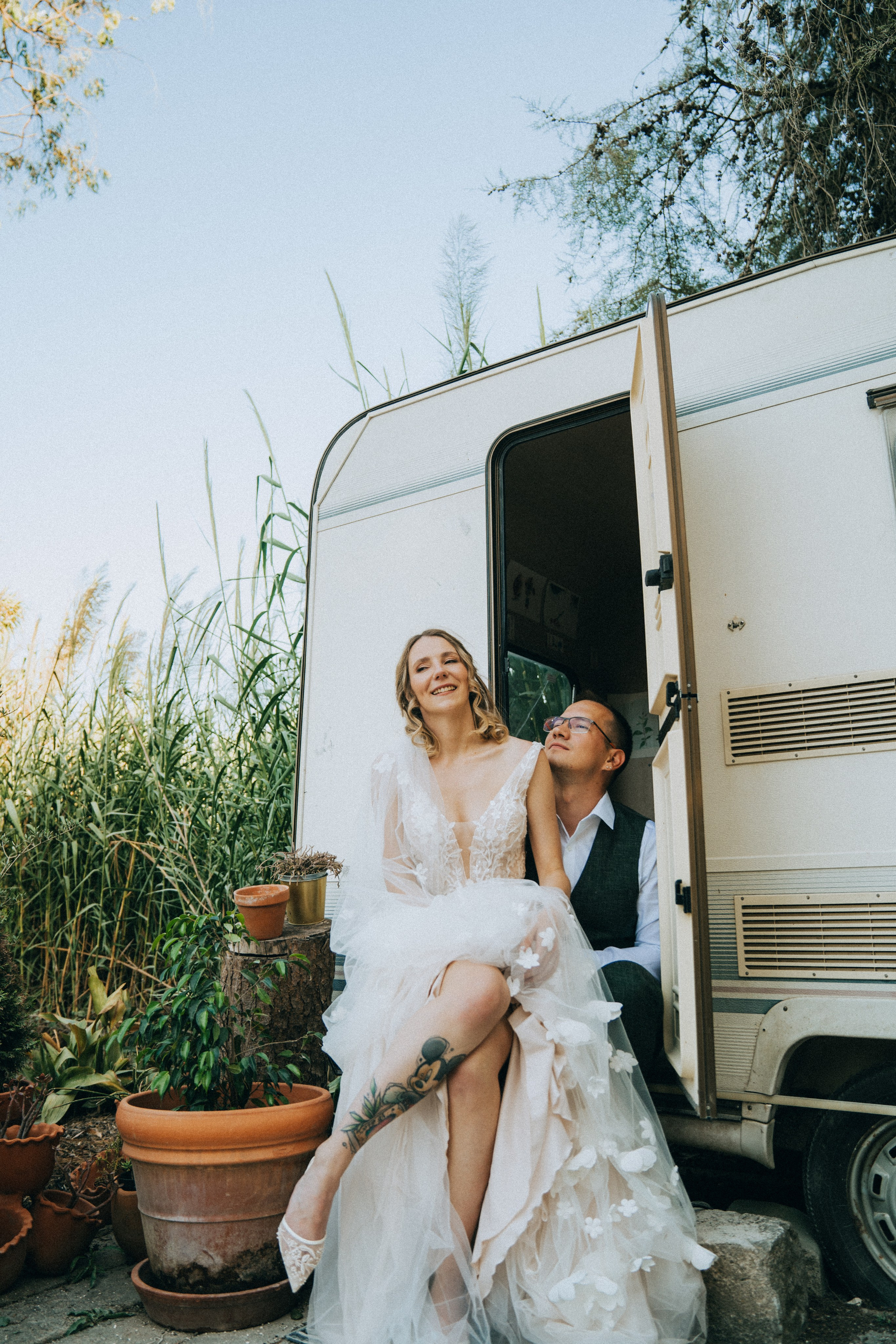 Влюбленная  пара жених и невеста целуется и обнимаются на фоне автодома