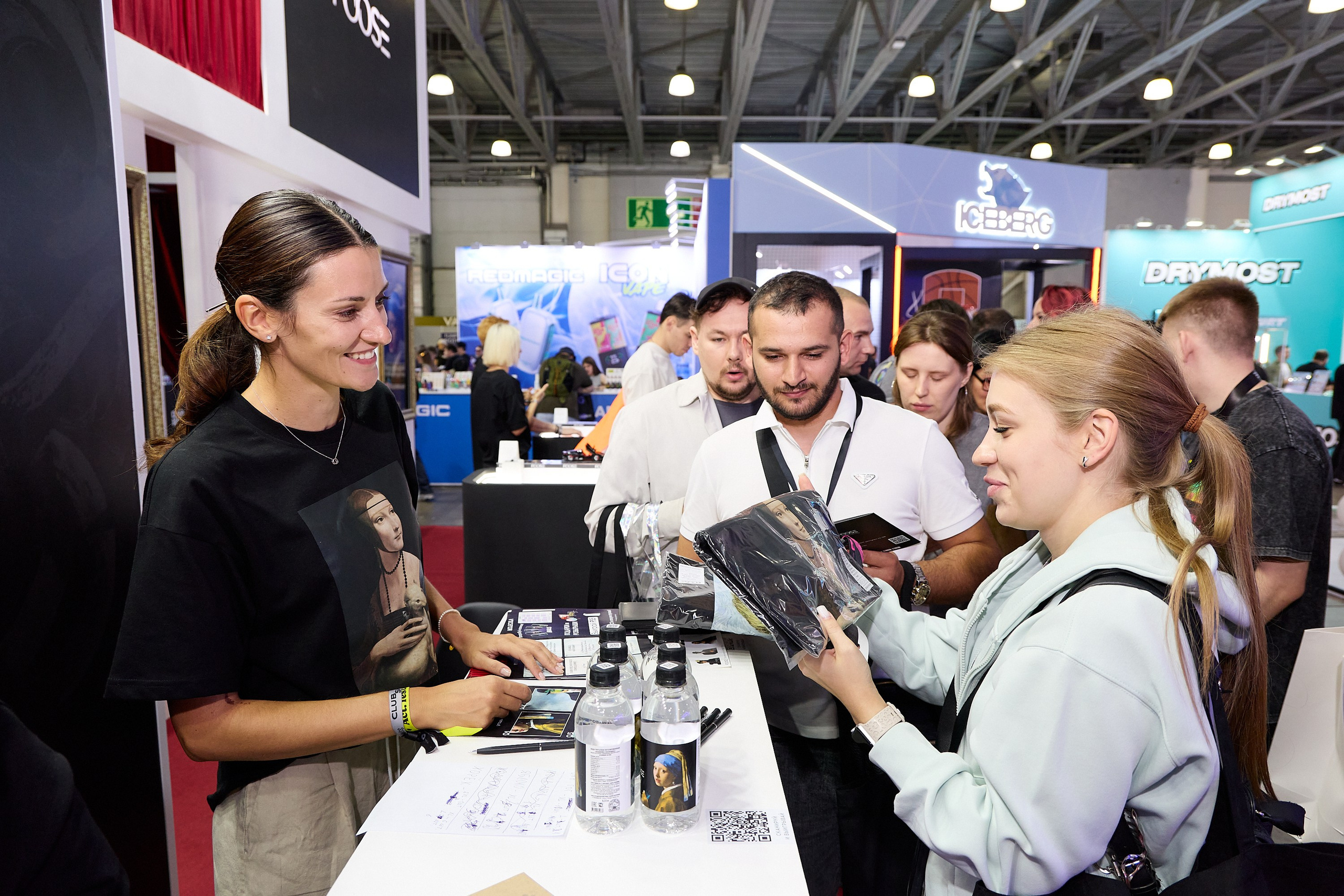 фотография передачи мерча на выставке 