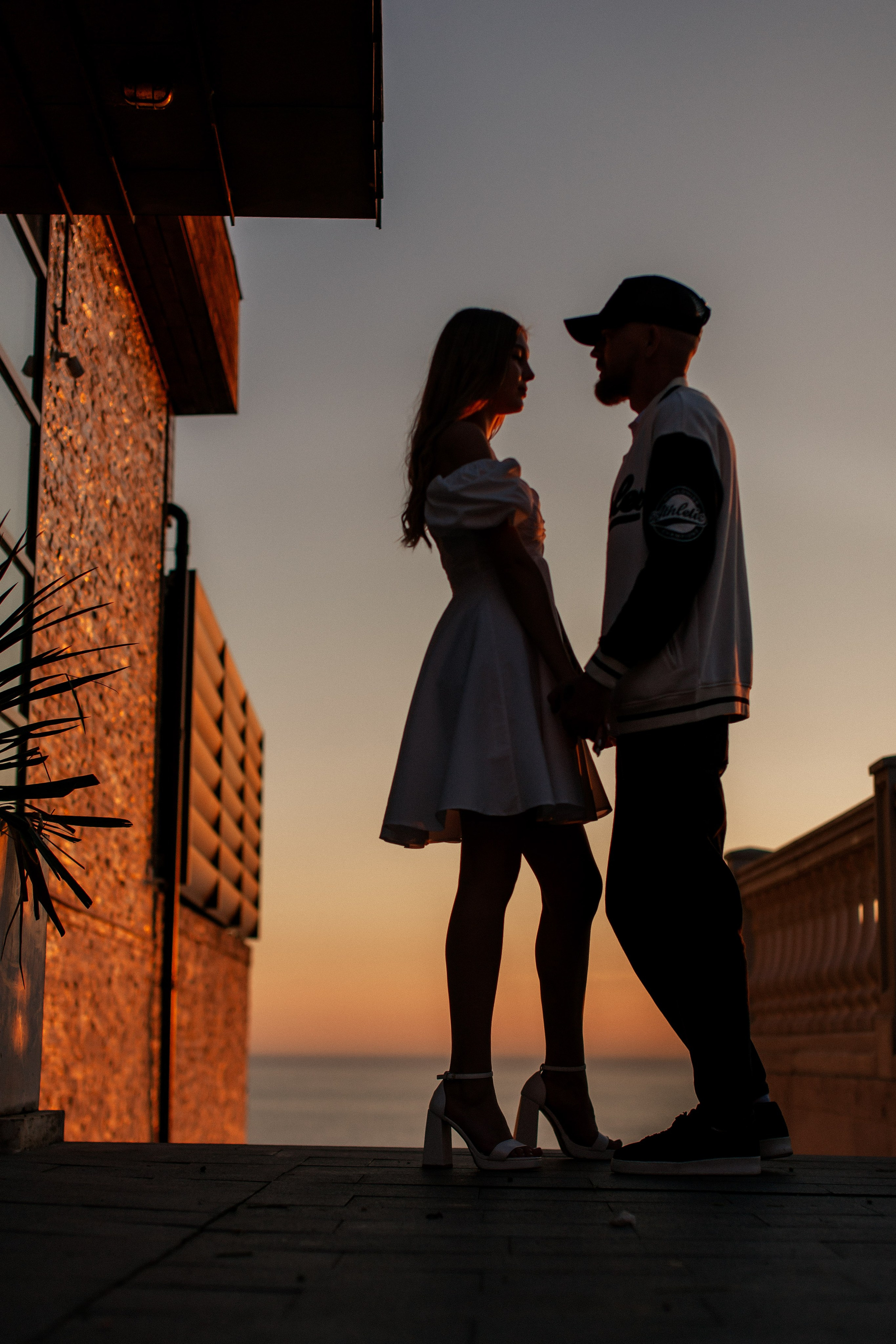 Силуэт пары на закате в Анапе, жених и невеста смотрят друг другу в глаза. 