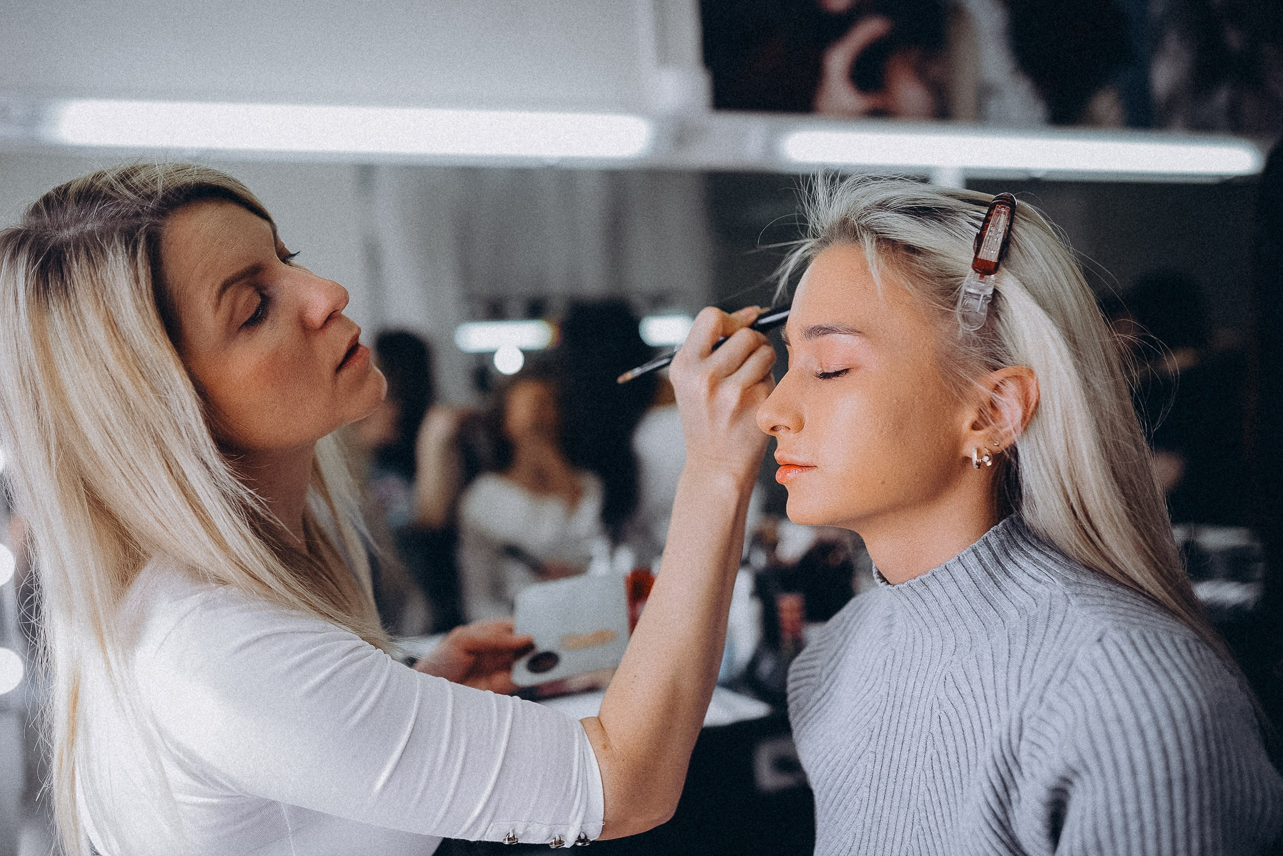 Визажист использует профессиональные кисти для создания идеального тона кожи модели.