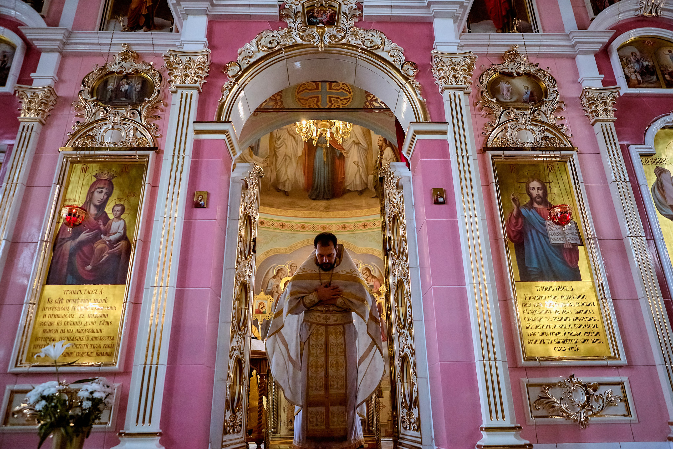 Стоит Священник со сложенными руками крестообразно на груди в Царских вратах