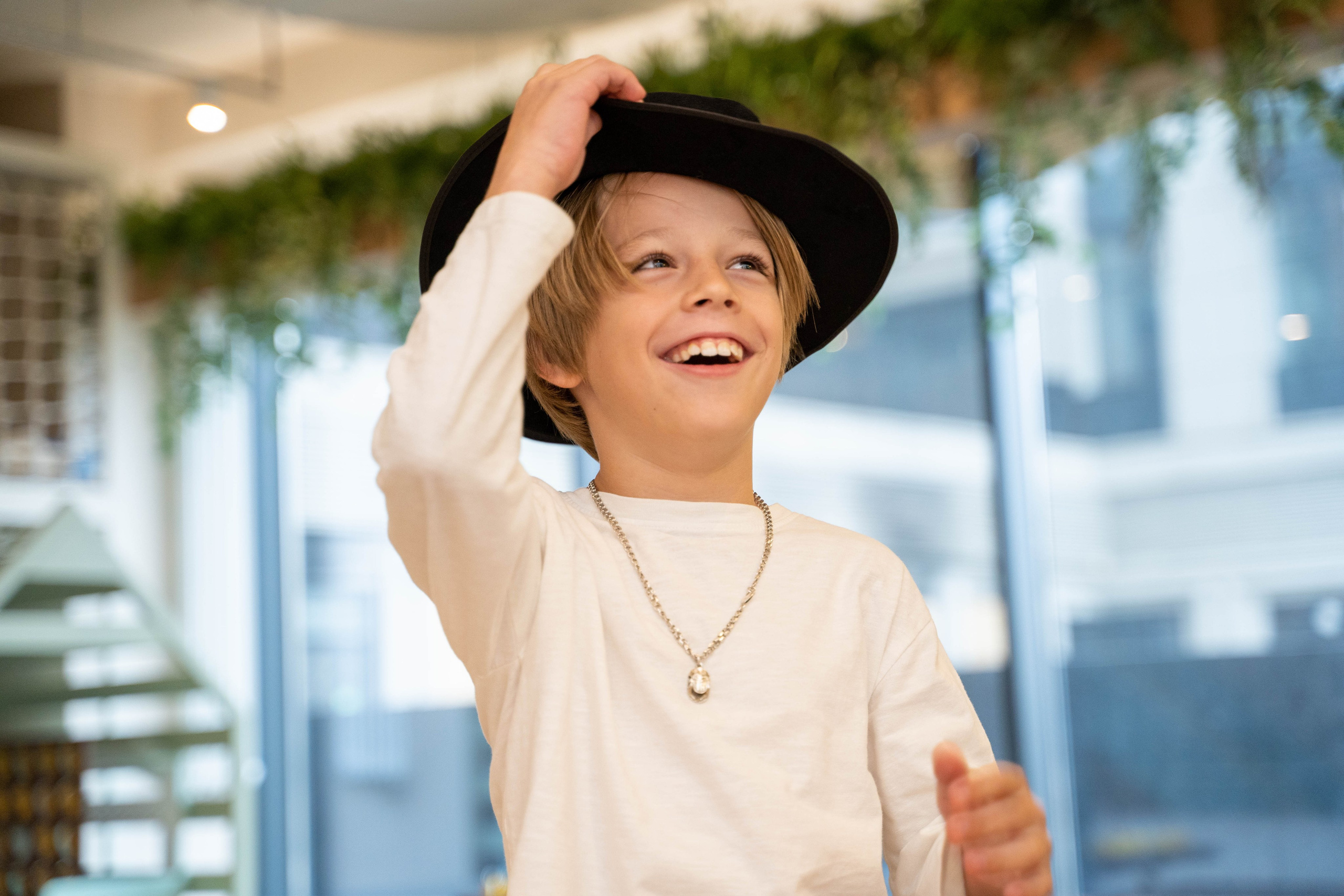 Улыбающийся мальчик в черной шляпе