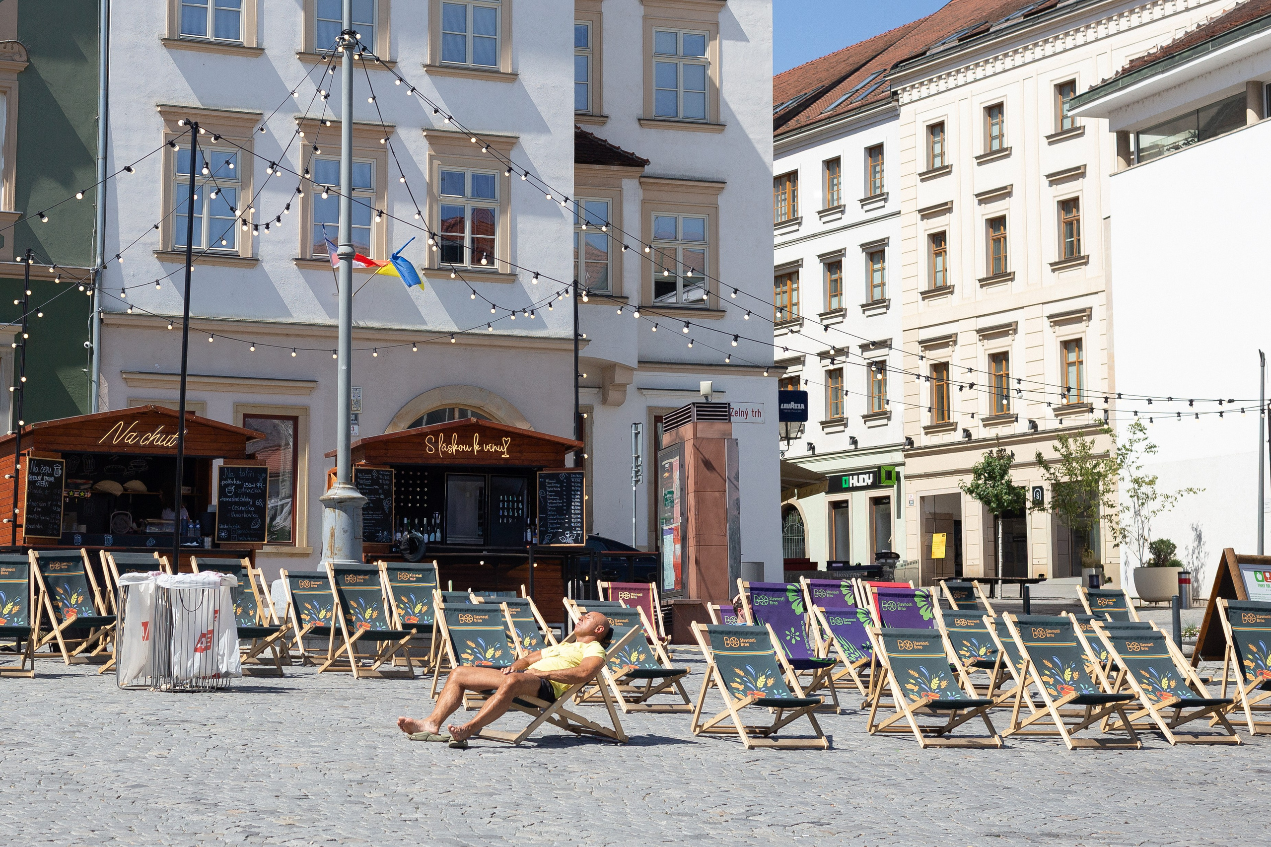 A man is relaxing in a square in Brno.