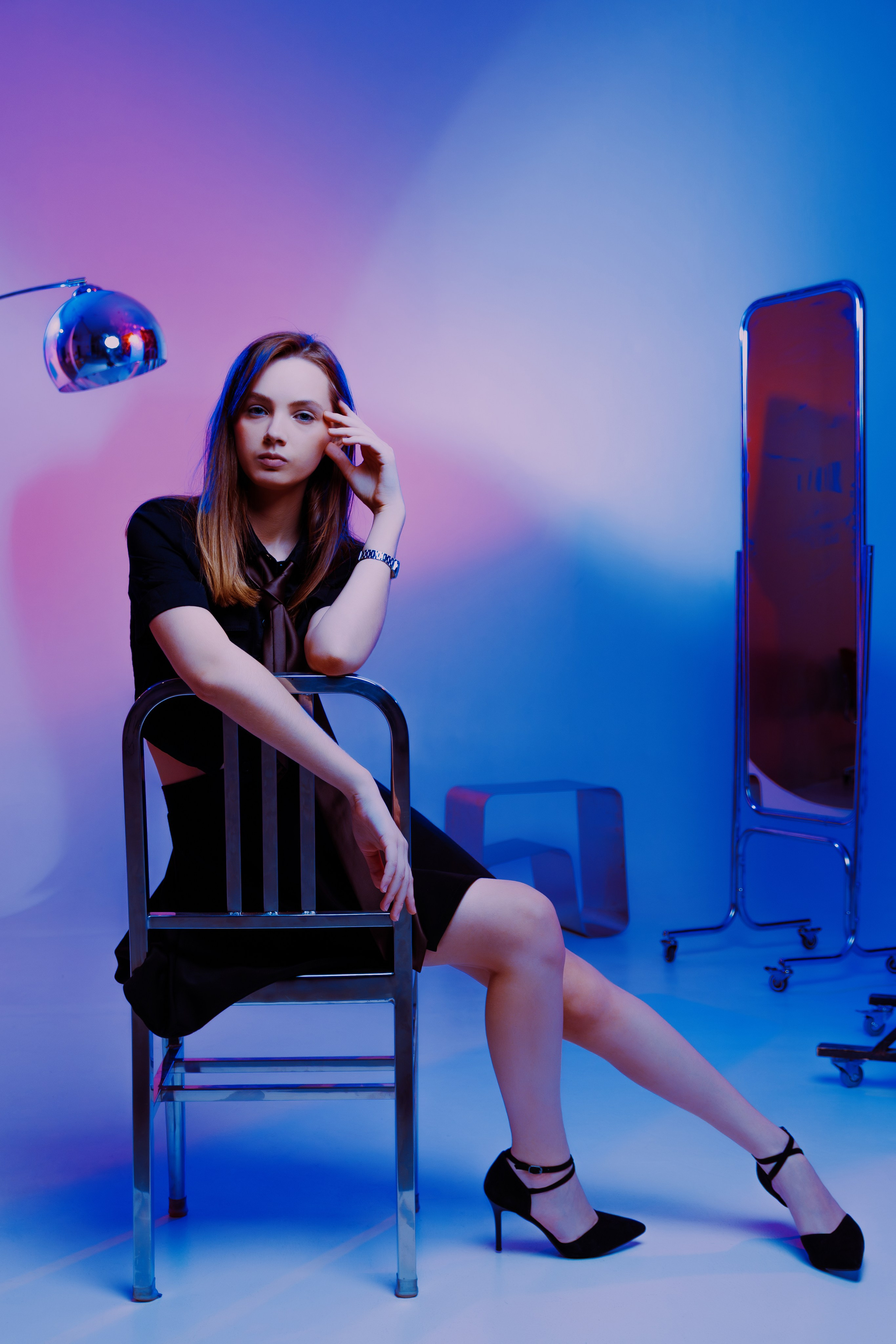 Хромированная лампа и градиентный фон — ключевые элементы этой студийной съёмки. Модель в лаконичном образе выглядит эффектно.