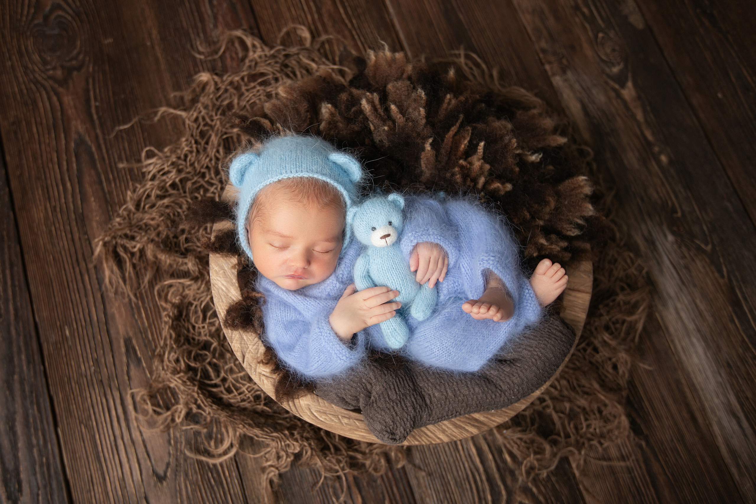 новорожденный малыш в корзинке в голубом костюме  и шапочке с ушками