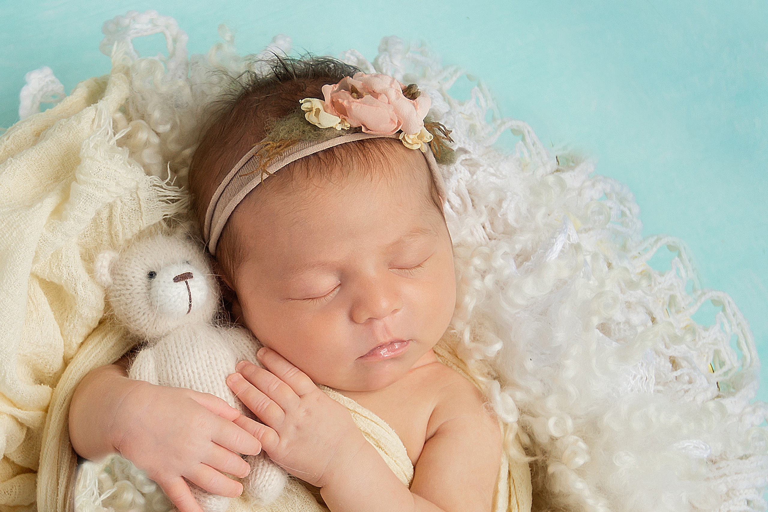 портрет новорожденного малыша в ободочке из цветов с мишкой