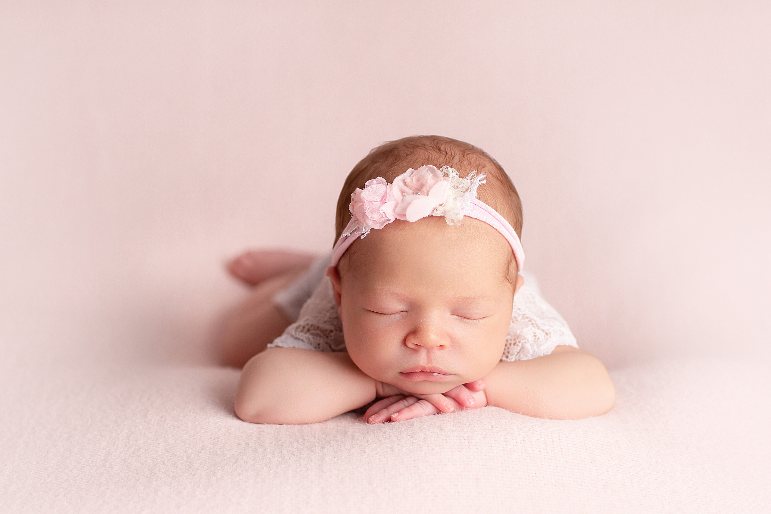 новорожденный малыш позировка на животике на подушке ручки под подбородком