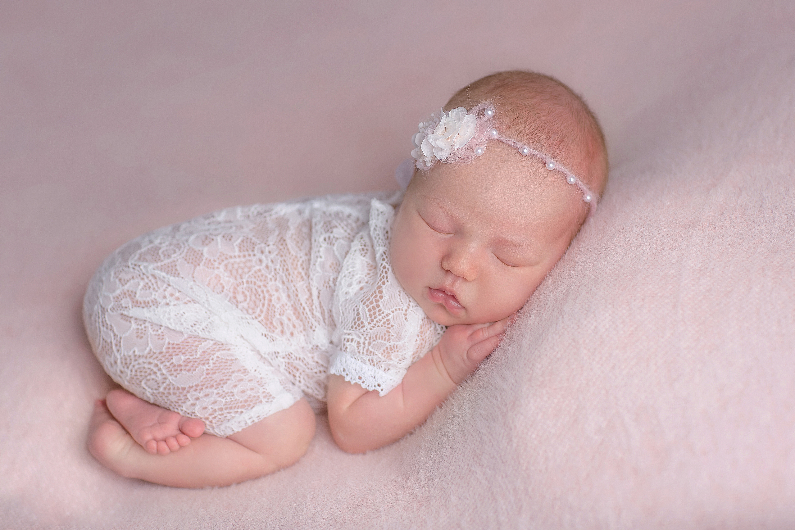 новорожденный малыш в белом боди костюме