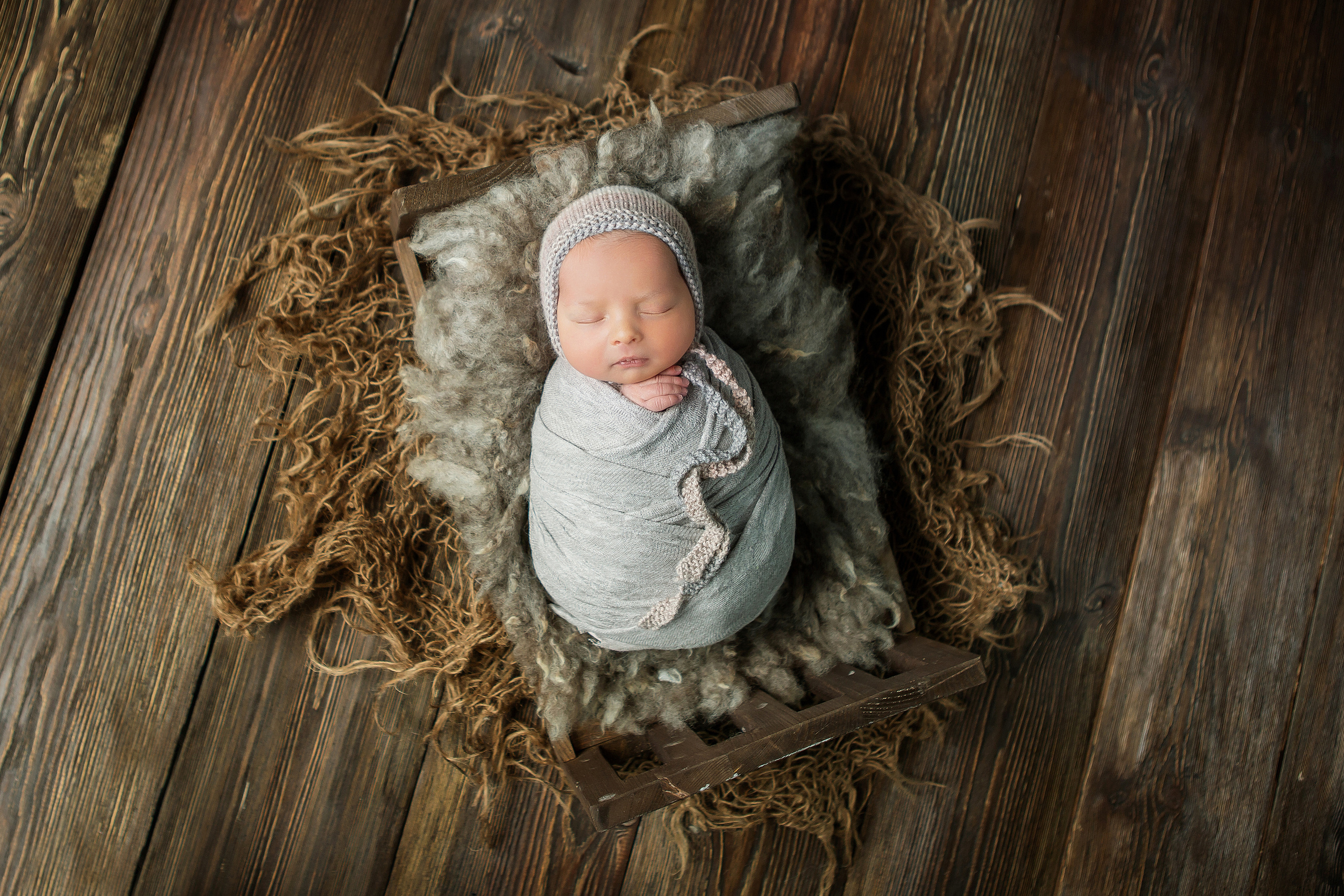 спящий новорожденный малыш в кроватке. фото сверху