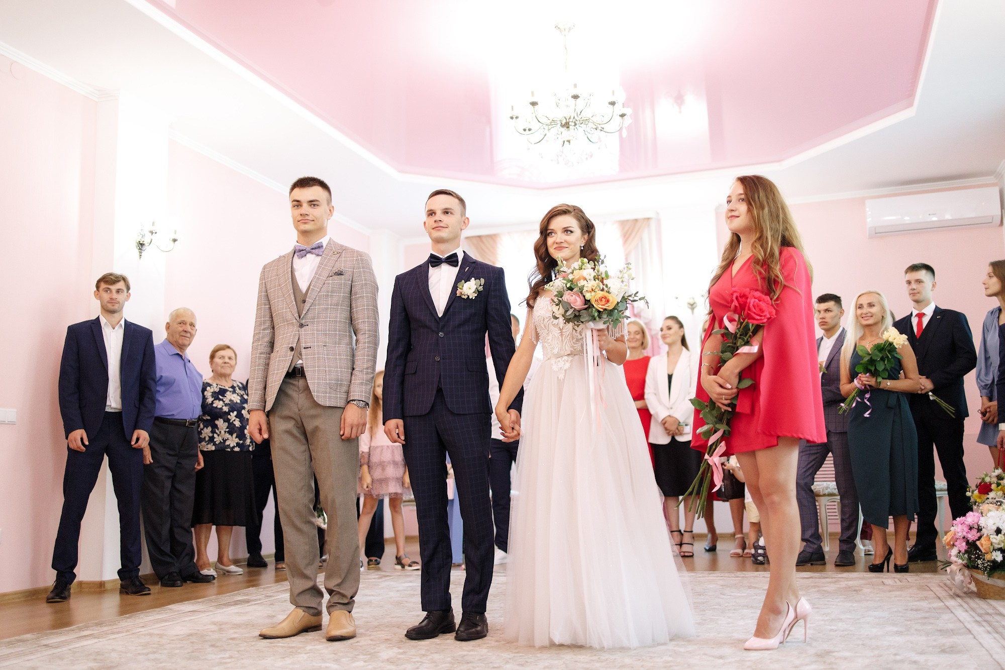 молодожены стоят в загсе со свидетелями 