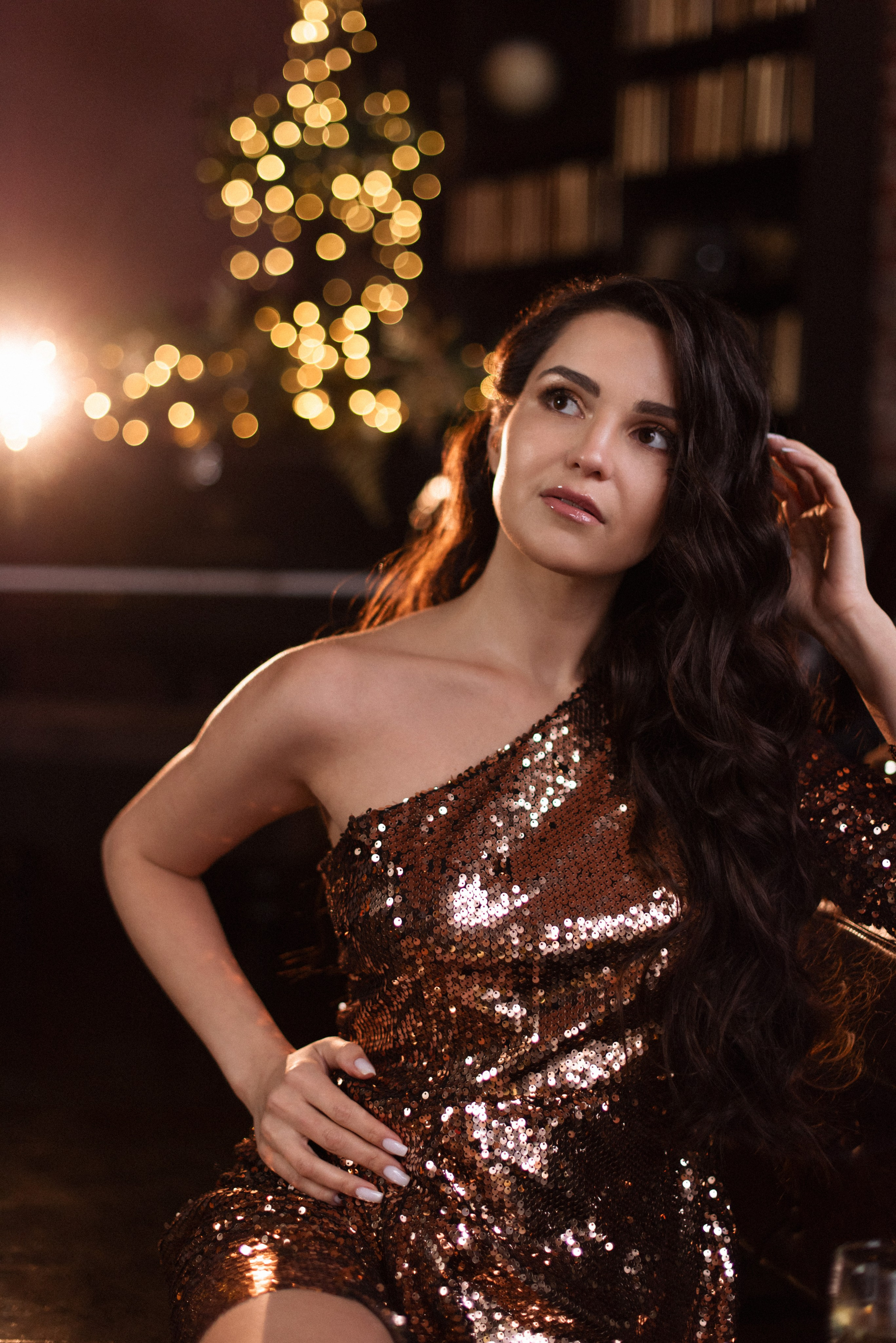Профессиональная новогодняя фотосессия: модель в блестящем бронзовом платье в лофте.