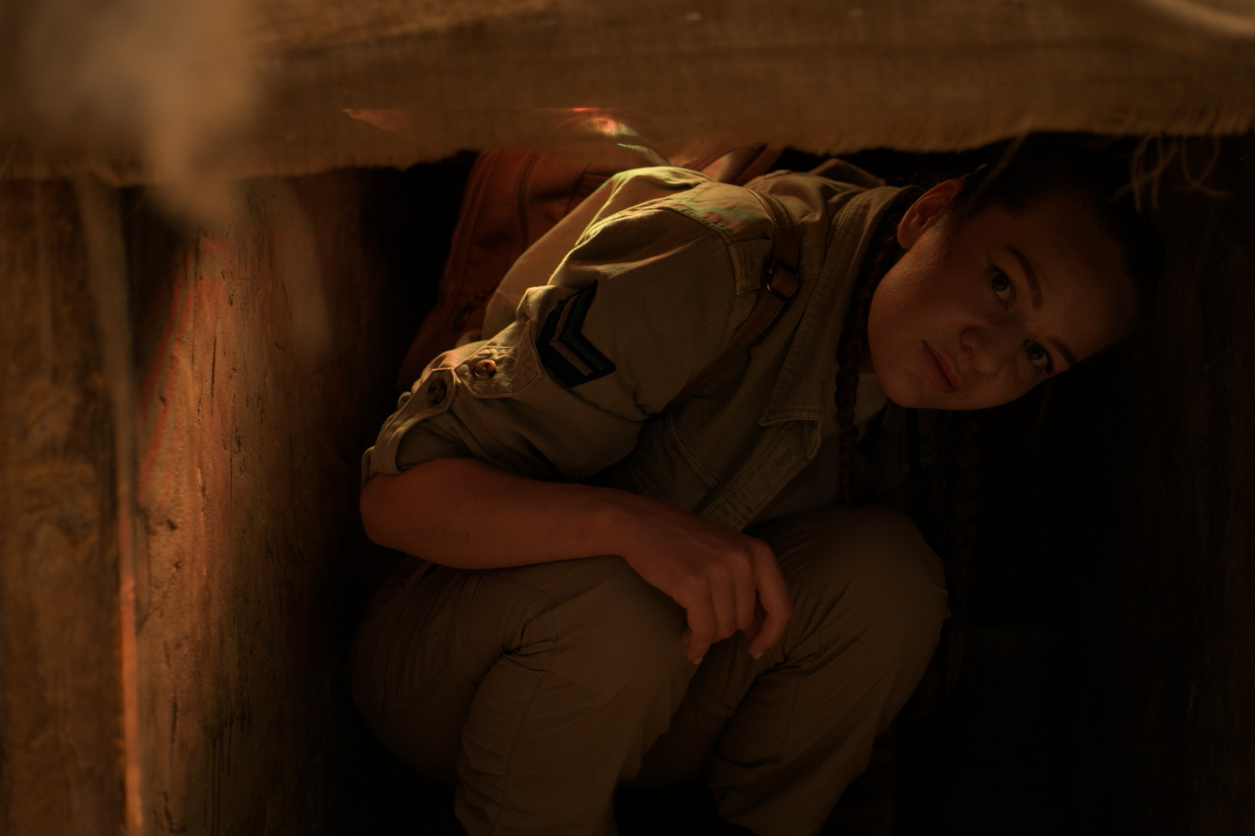 Девушка в костюме исследователя в туннеле с фонариком