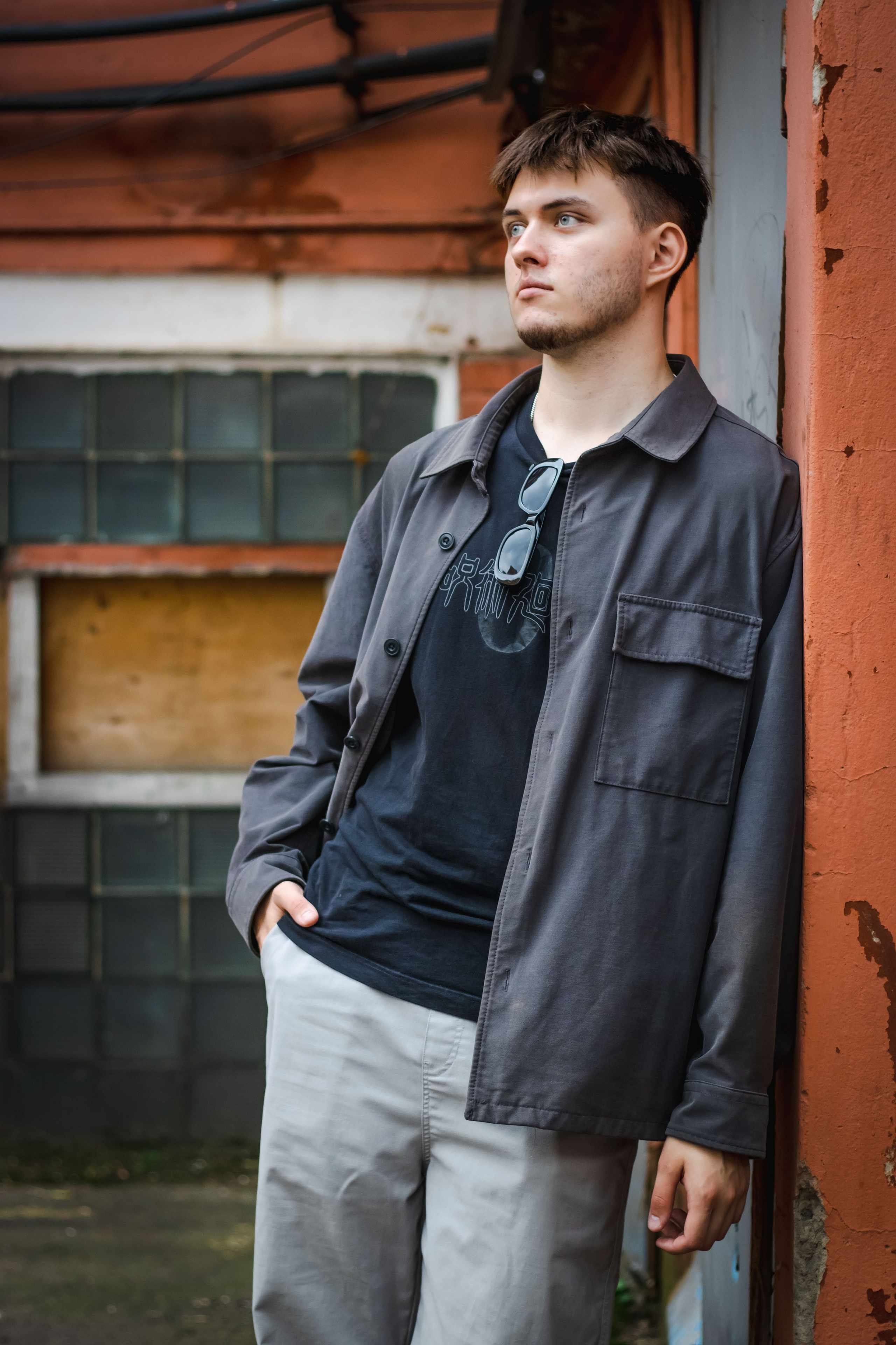 парень оперся об стену на улице и задумался о жизни