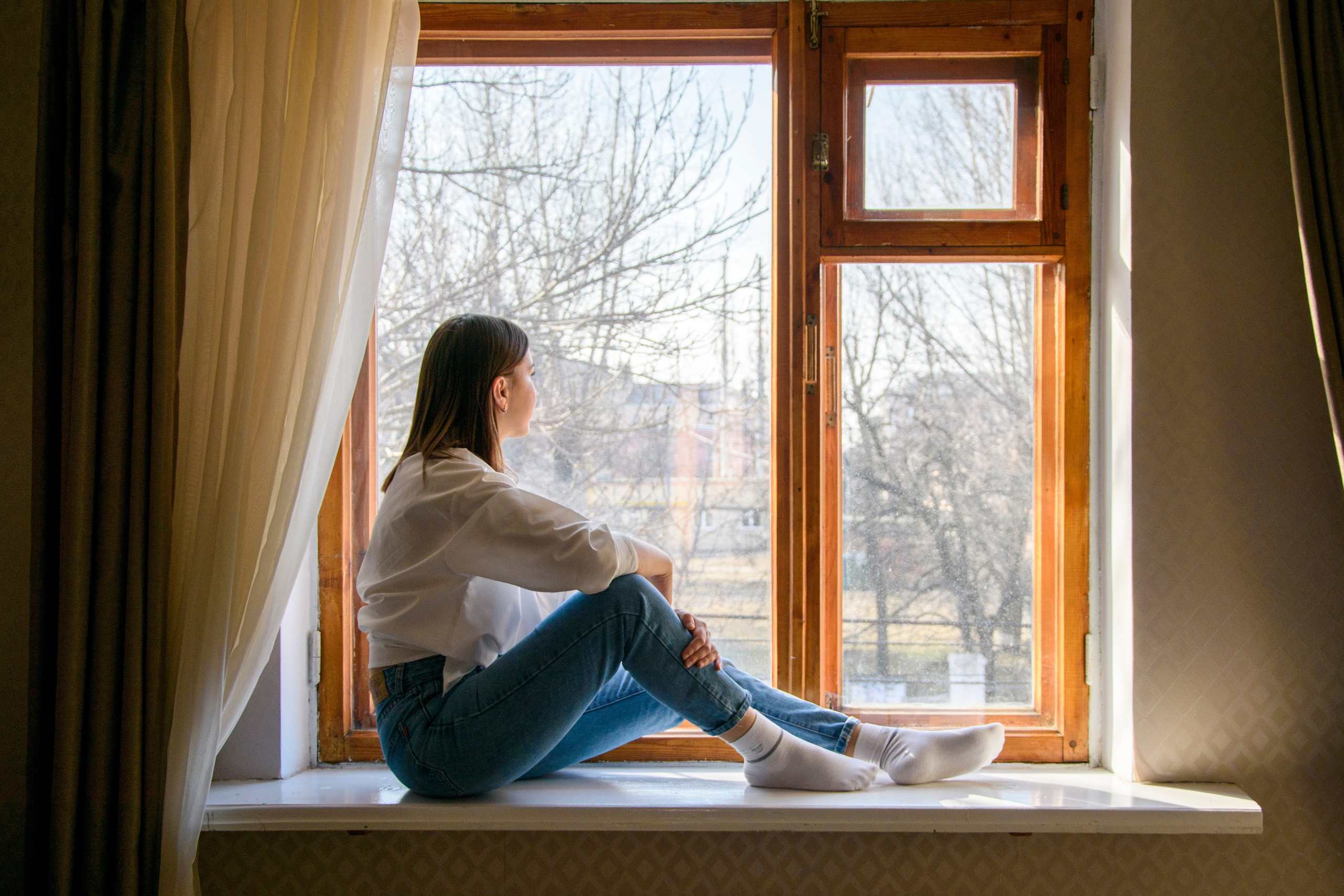девушка сидит на подоконнике, рама окна