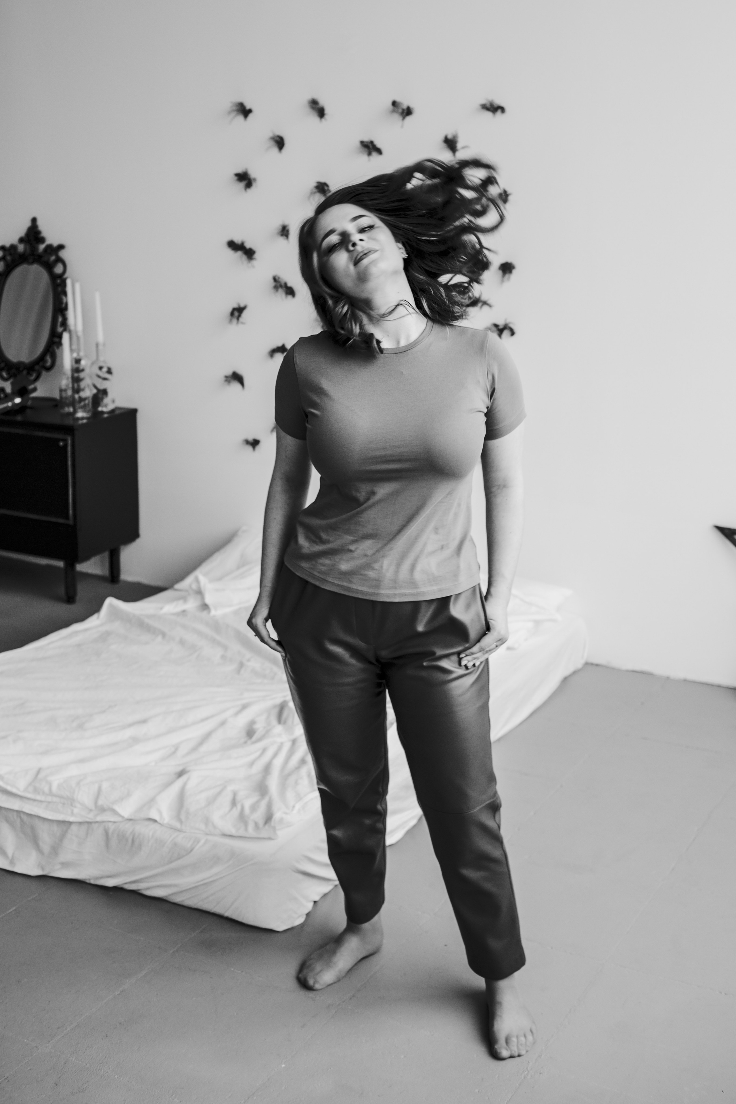 Креативная фотография; модель в кадре двигает головой, её волосы эстетично развеваются в кадре.