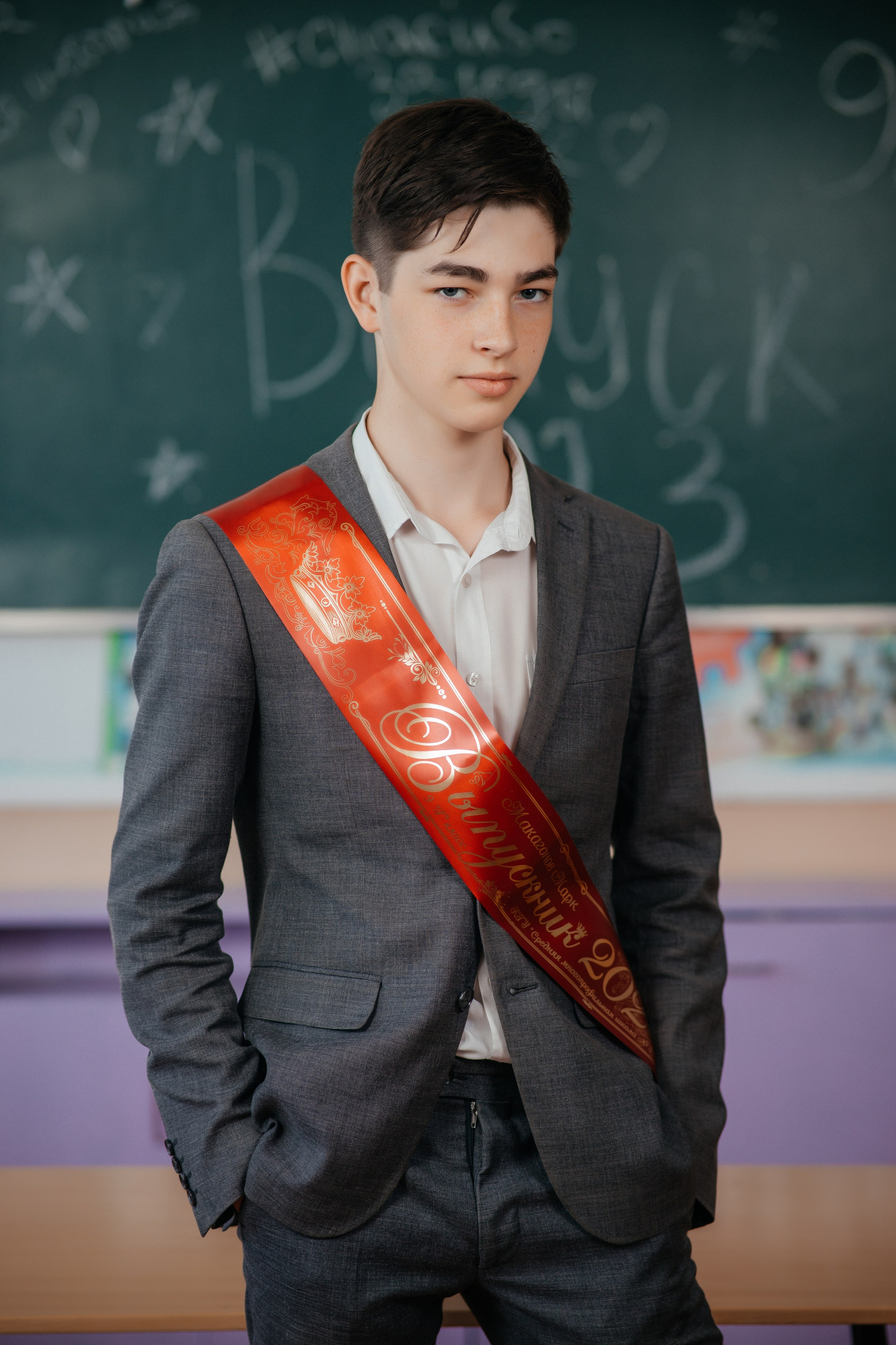 Выпускник с лентой выпускника на фотосъемке для выпускного альбома г. Усть-Каменогорск