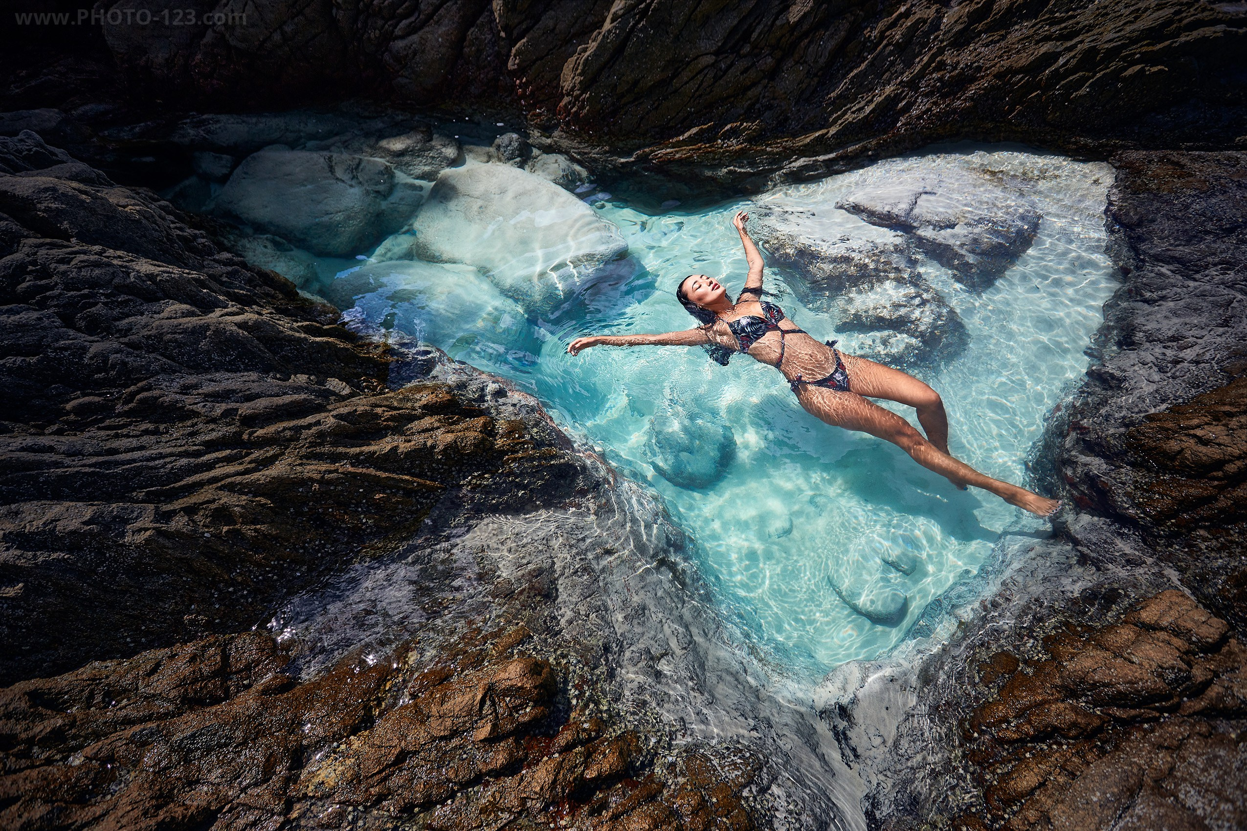 Stunning lifestyle shot of a model in a natural crystal-clear rock pool in Nha Trang.