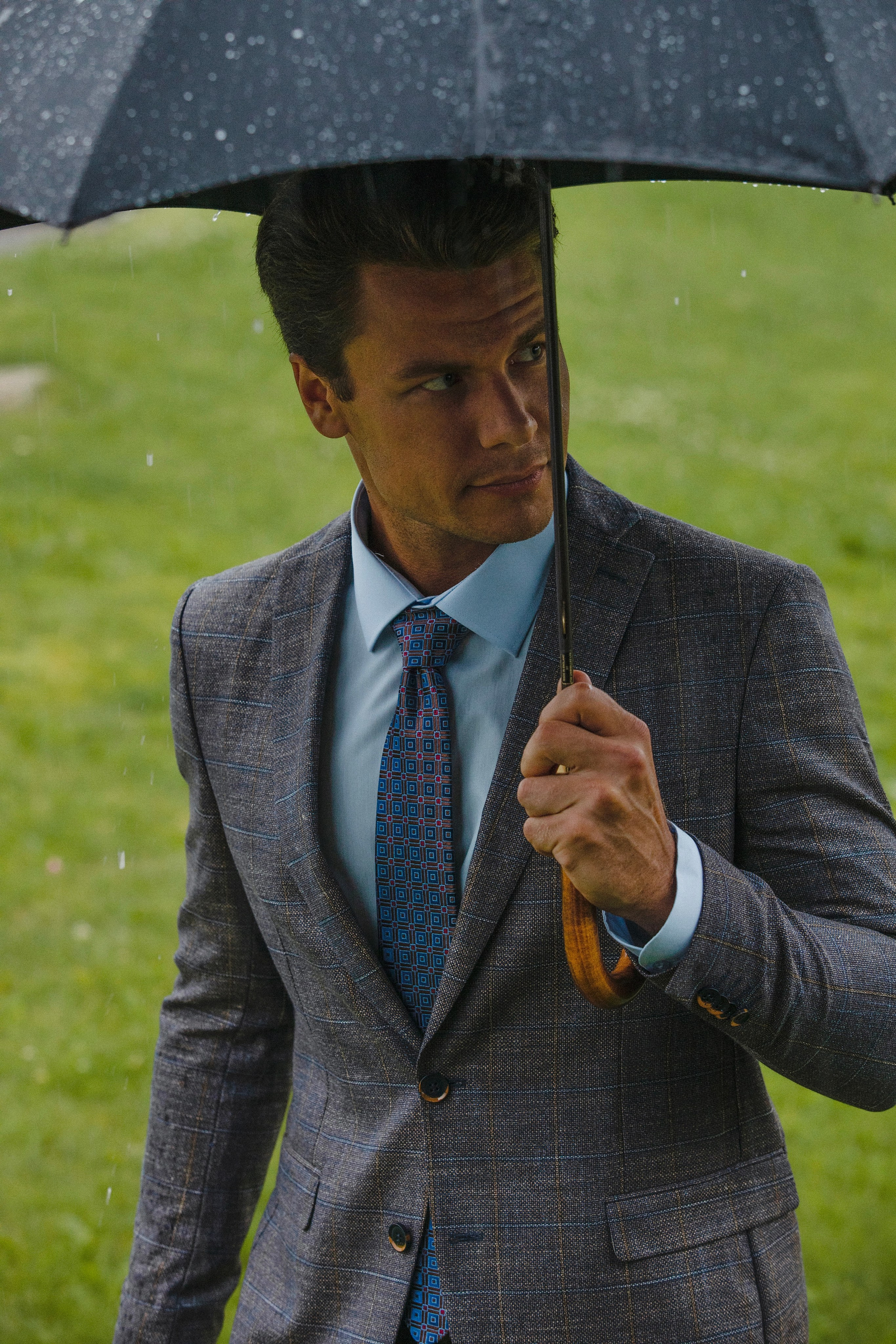 Мужчина модель в деловом костюме с зонтом в руке