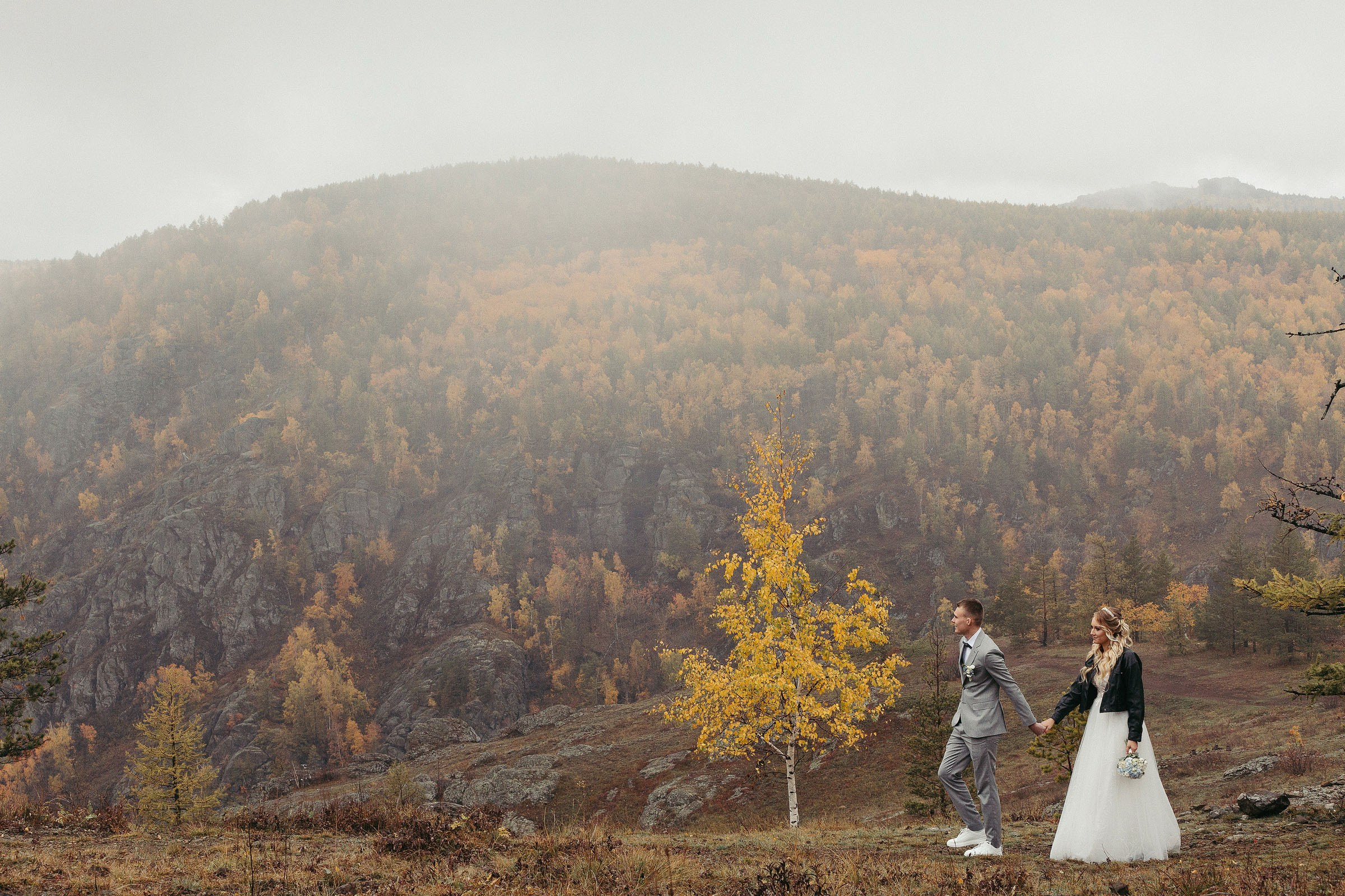 Молодая свадебная пара гуляет на вершине горы в тумане. Фотограф Андрей Куликов