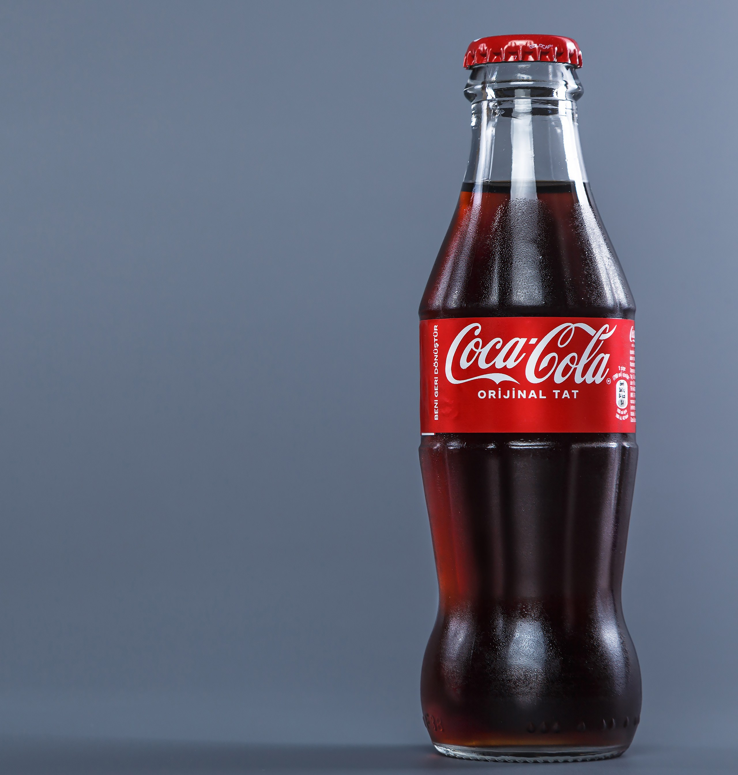 Coca-Cola в стекле серый фон каталожное фото