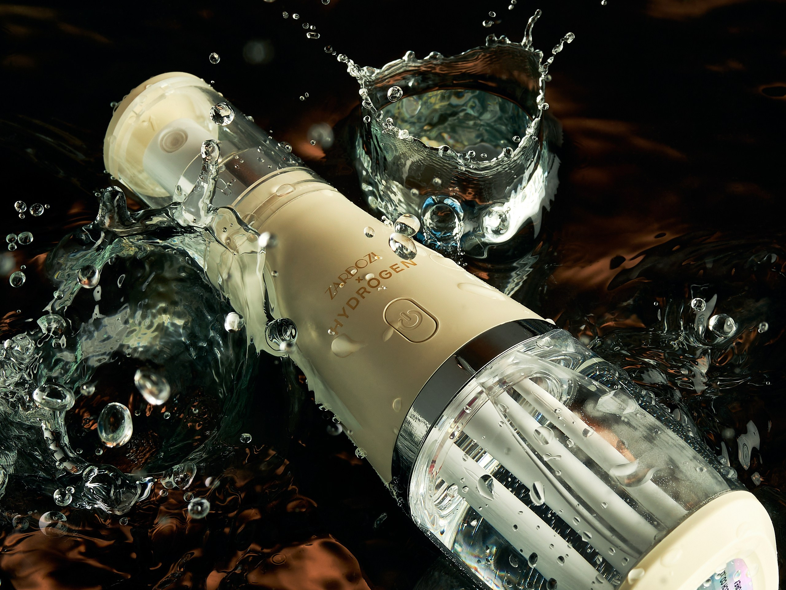 Флакон духов в воде с каплями и брызгами, создающими динамичный эффект