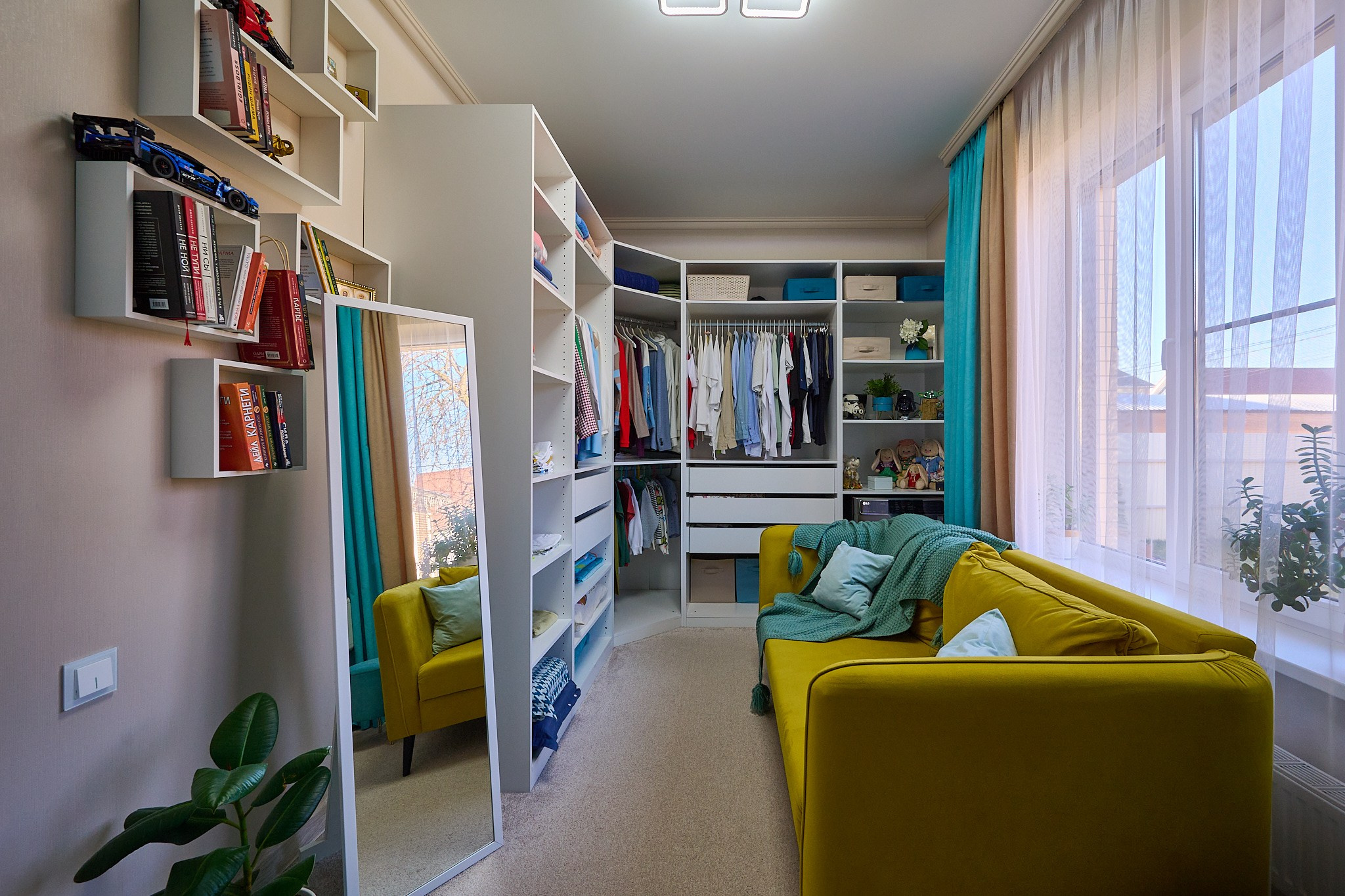 гардеробная с белыми шкафами и зеленым диваном и голубыми стенами 