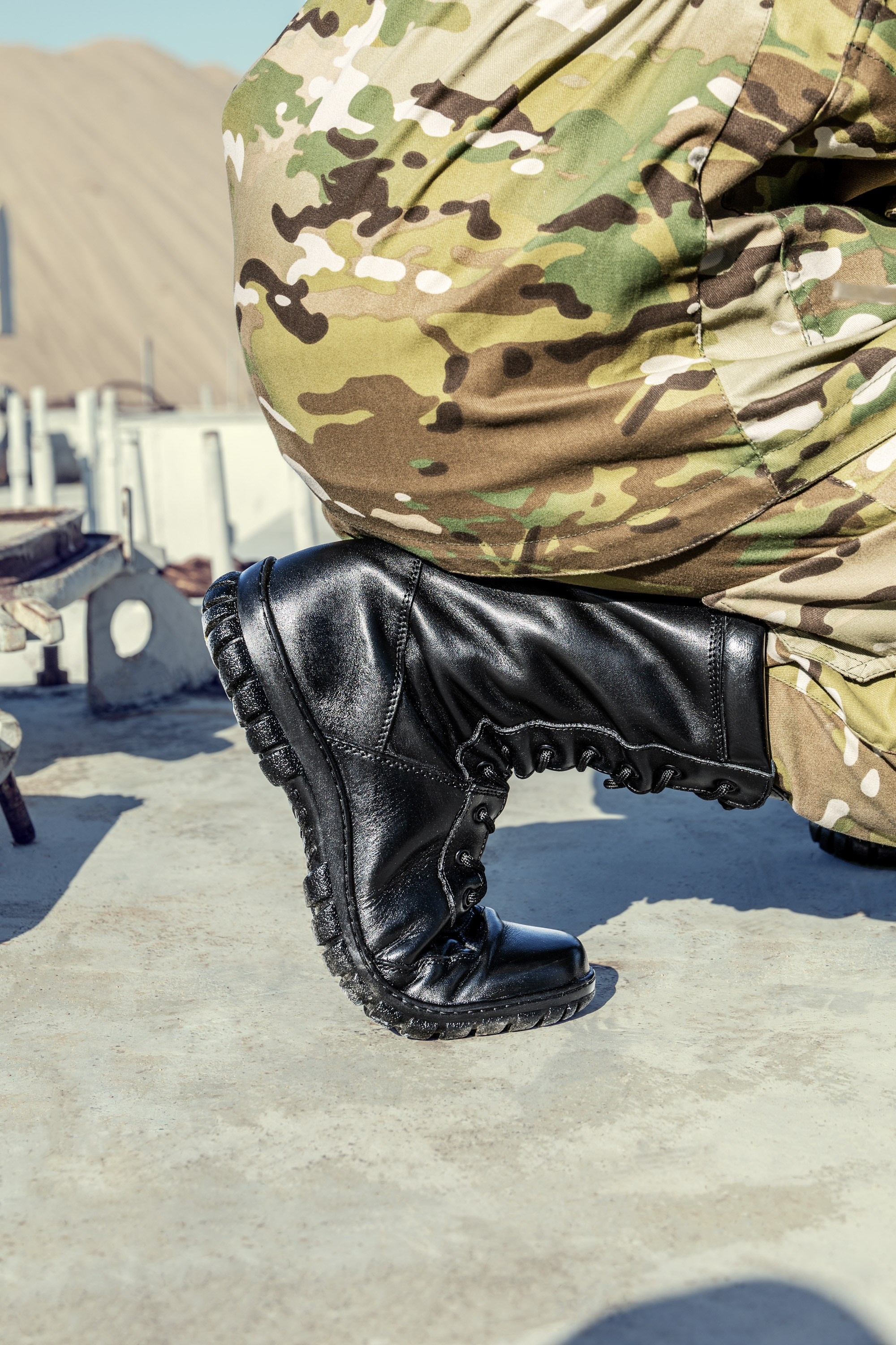 Боковой ракурс черных берцев на ноге в камуфляже | Детальная съемка профиля для каталога