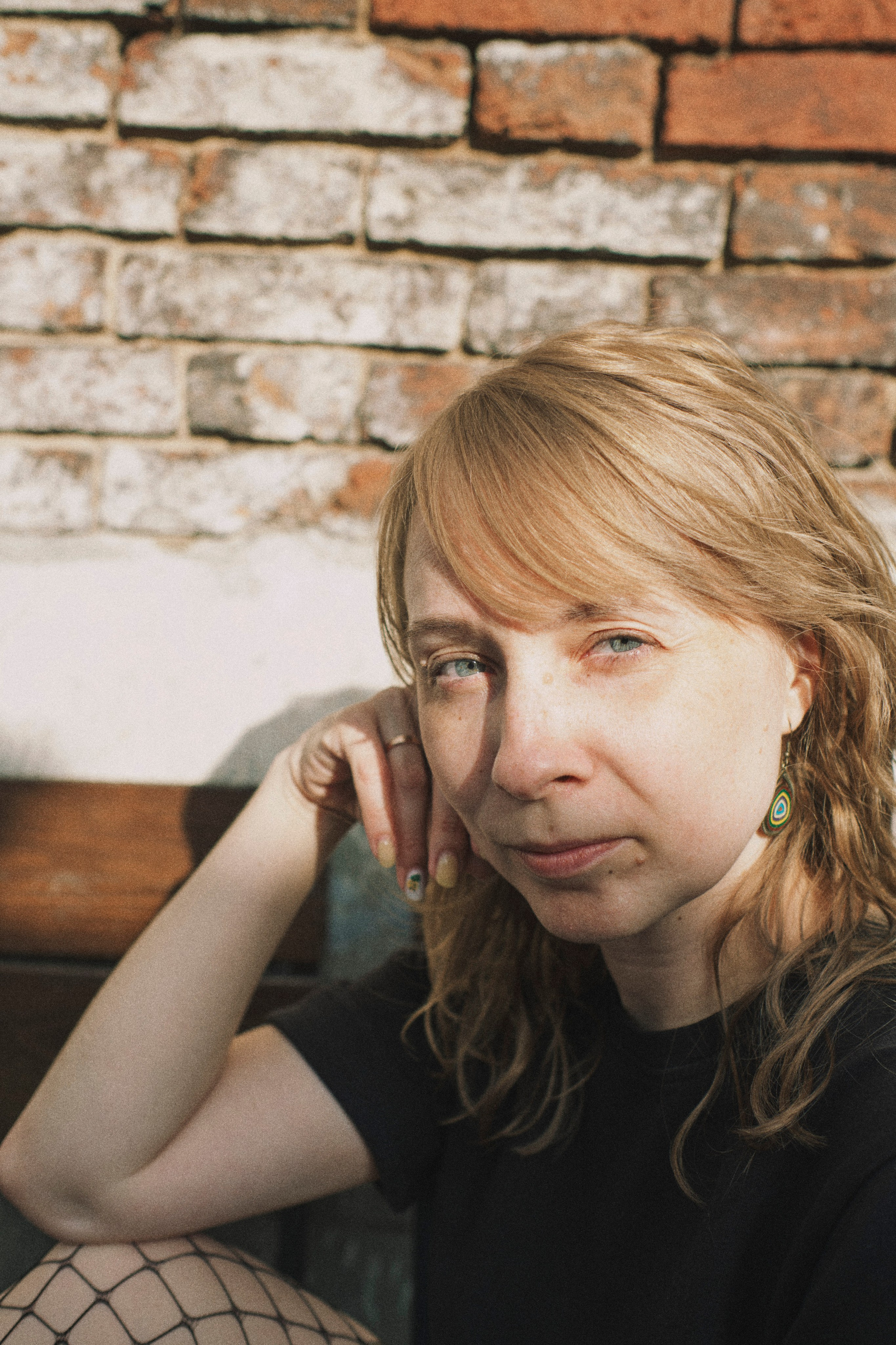 Близкий портрет женщины на фоне кирипичной стены