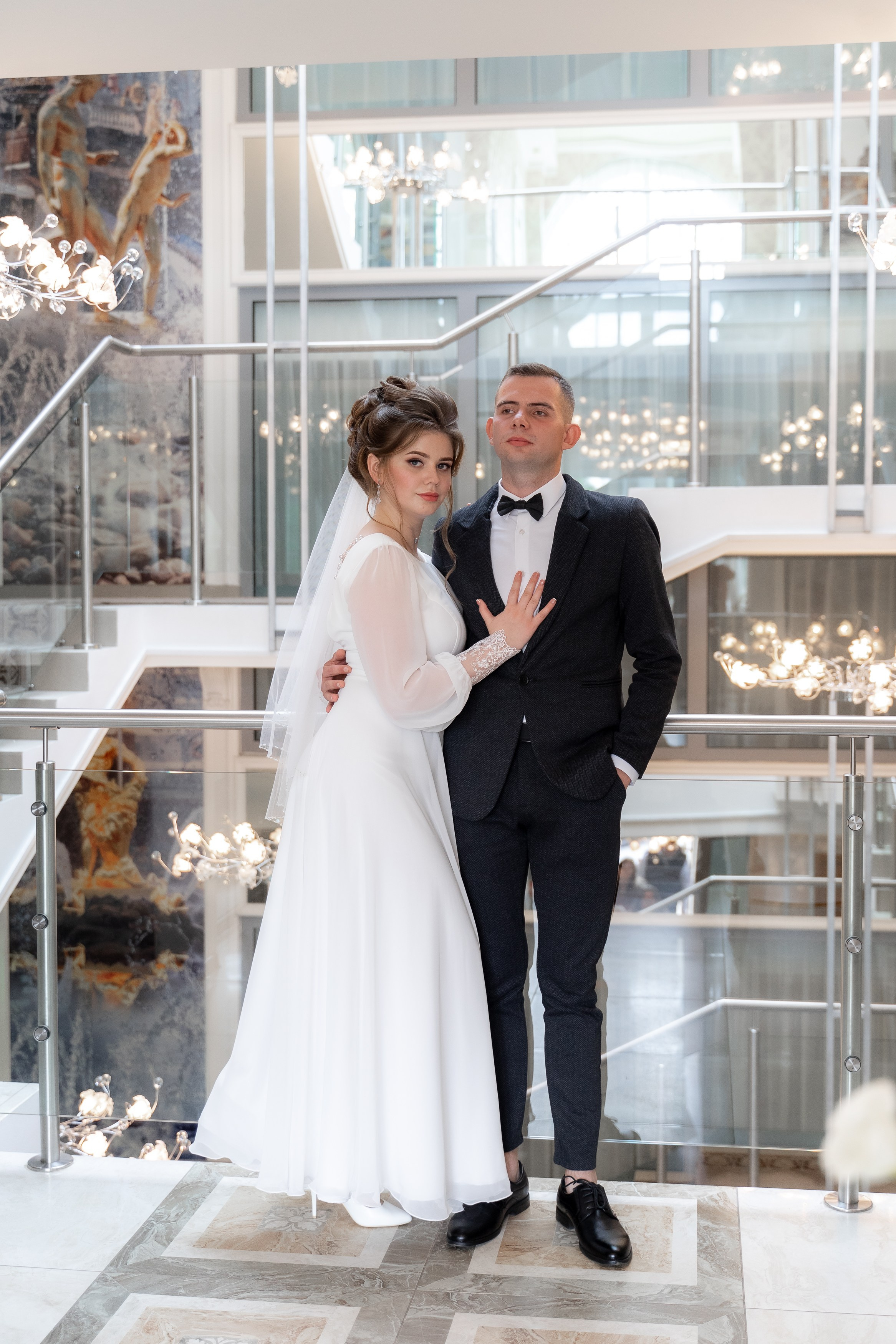 Свадебная фотосессия а загсе Петергофа. Пара позирует на лестнице.