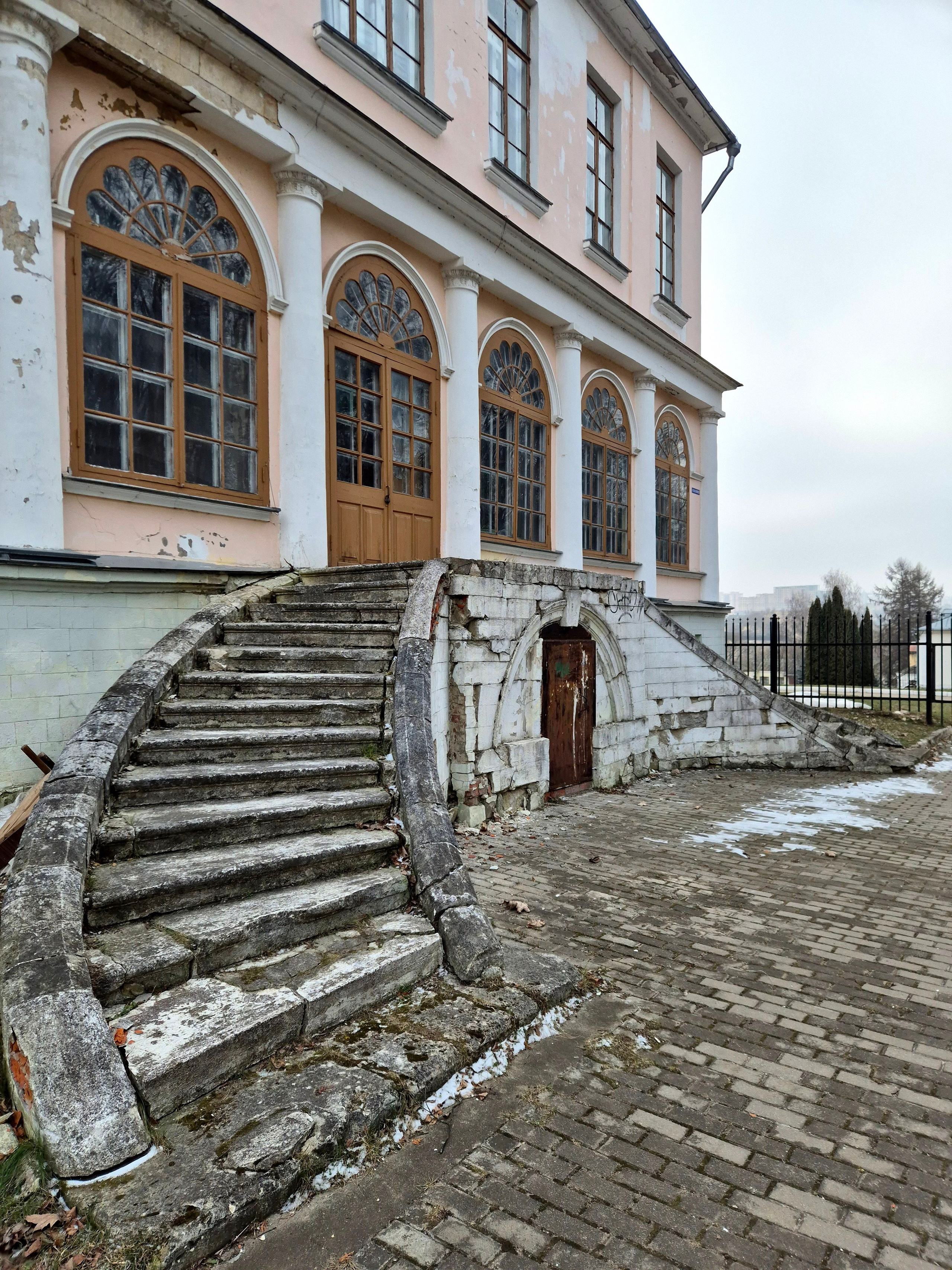 Круговые лестницы, примыкающие симметрично с двух сторон здания к боковым верандам