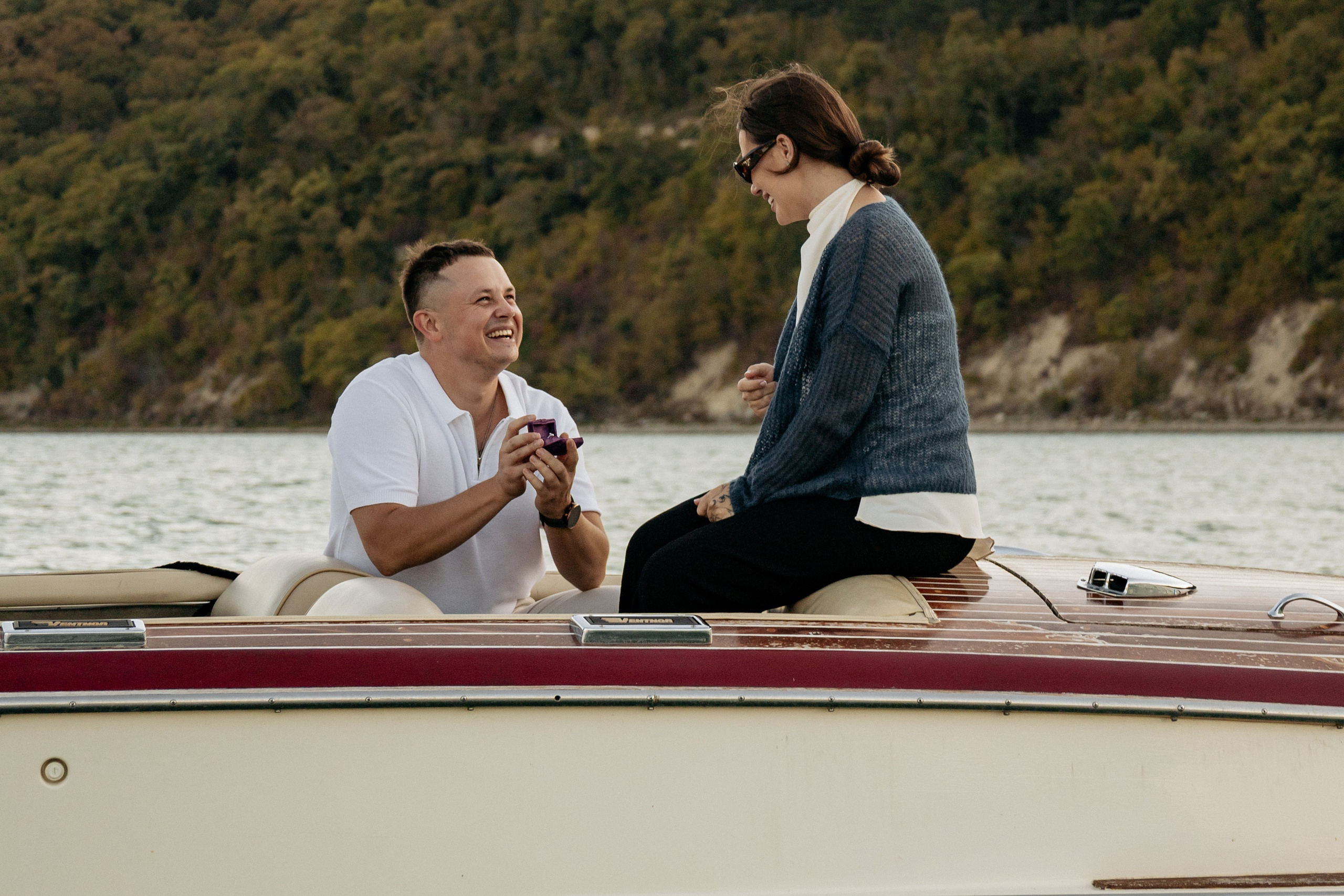 Счастливые влюбленные наслаждаются моментом уединения в лодке, на озере Абрау-Дюрсо