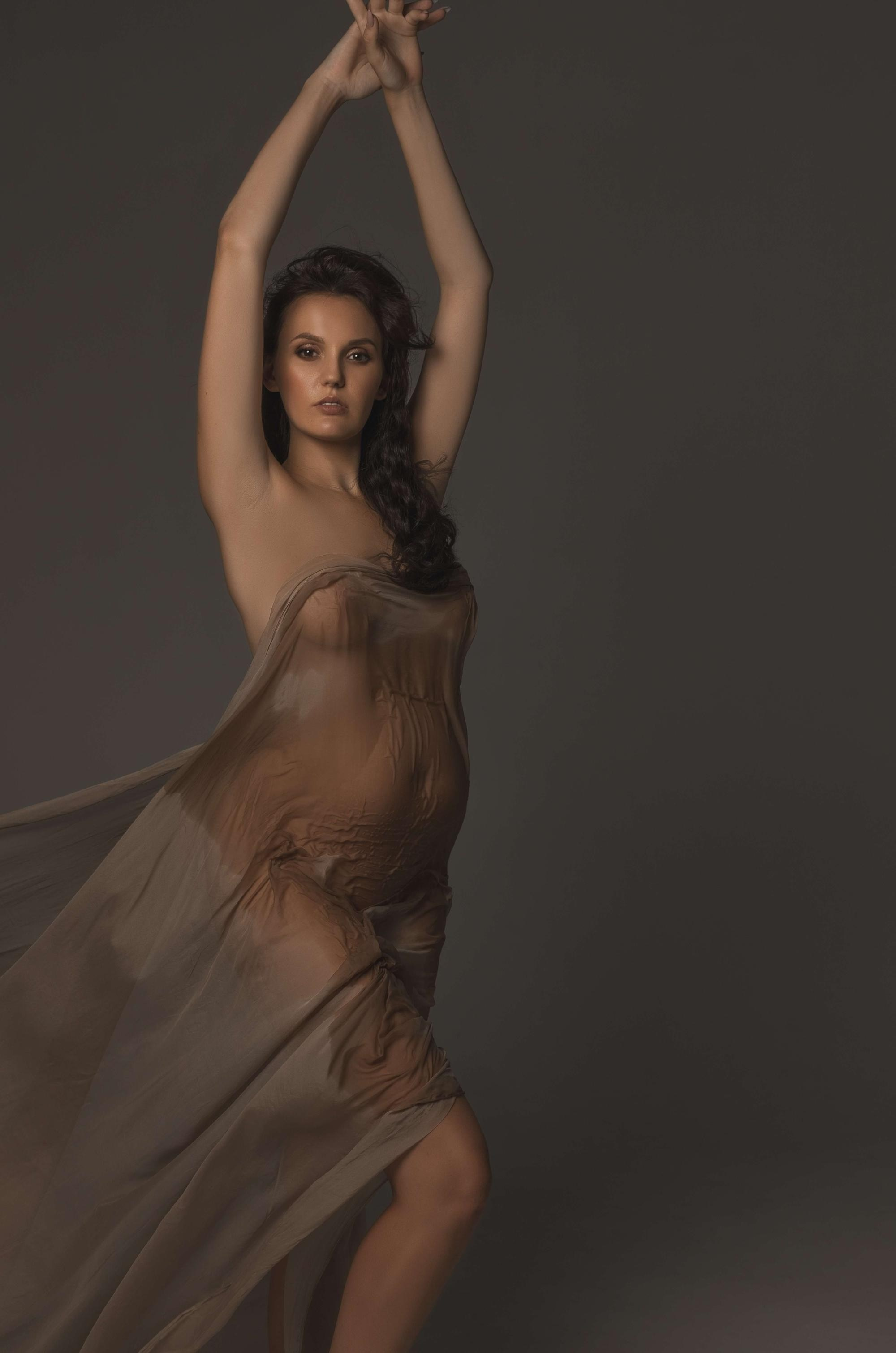 фотосессия беременной в фотостудии на темном фоне в красивом разлетающемся платье, фотография беременности, фотосессия беременных, портрет беременной