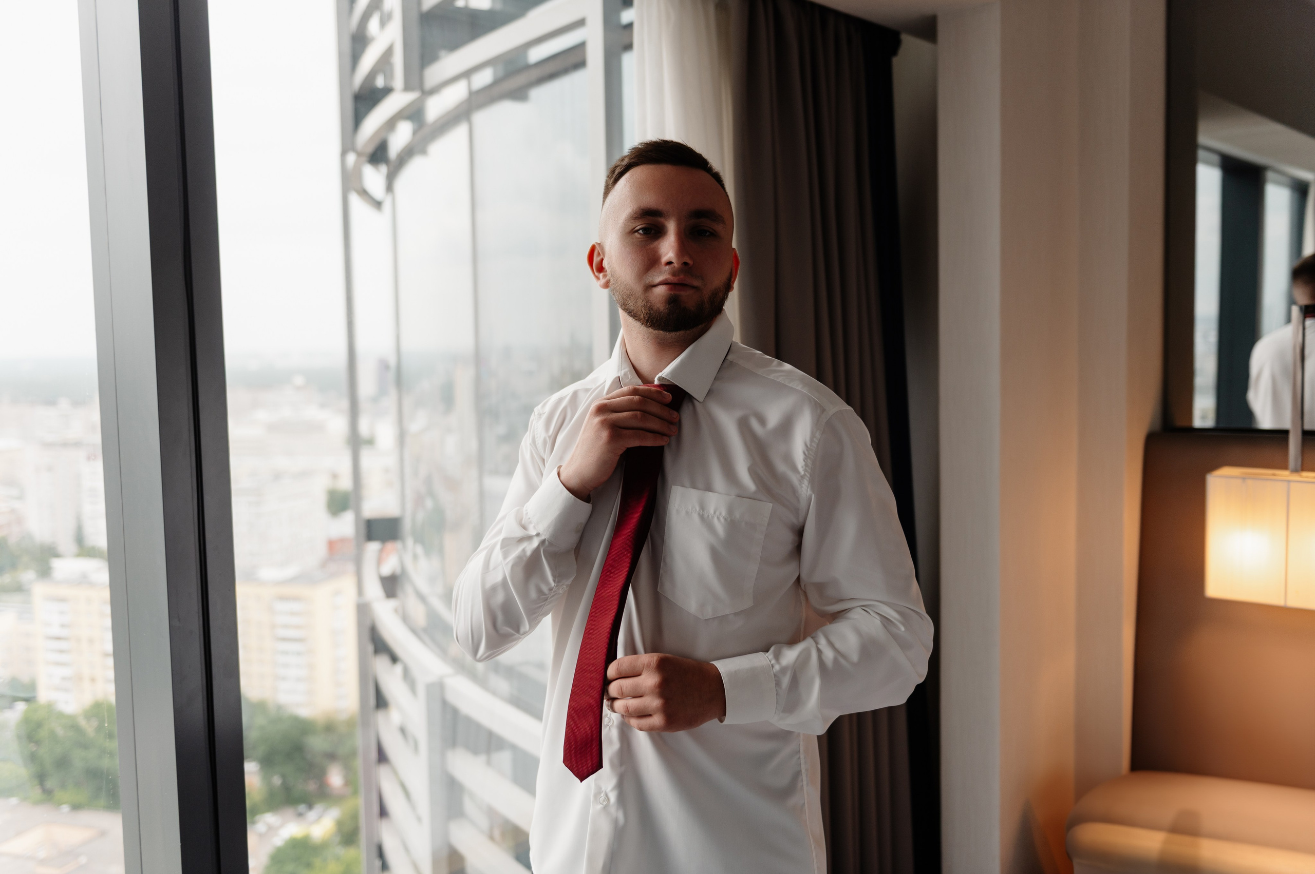 Жених поправляет свой галстук.