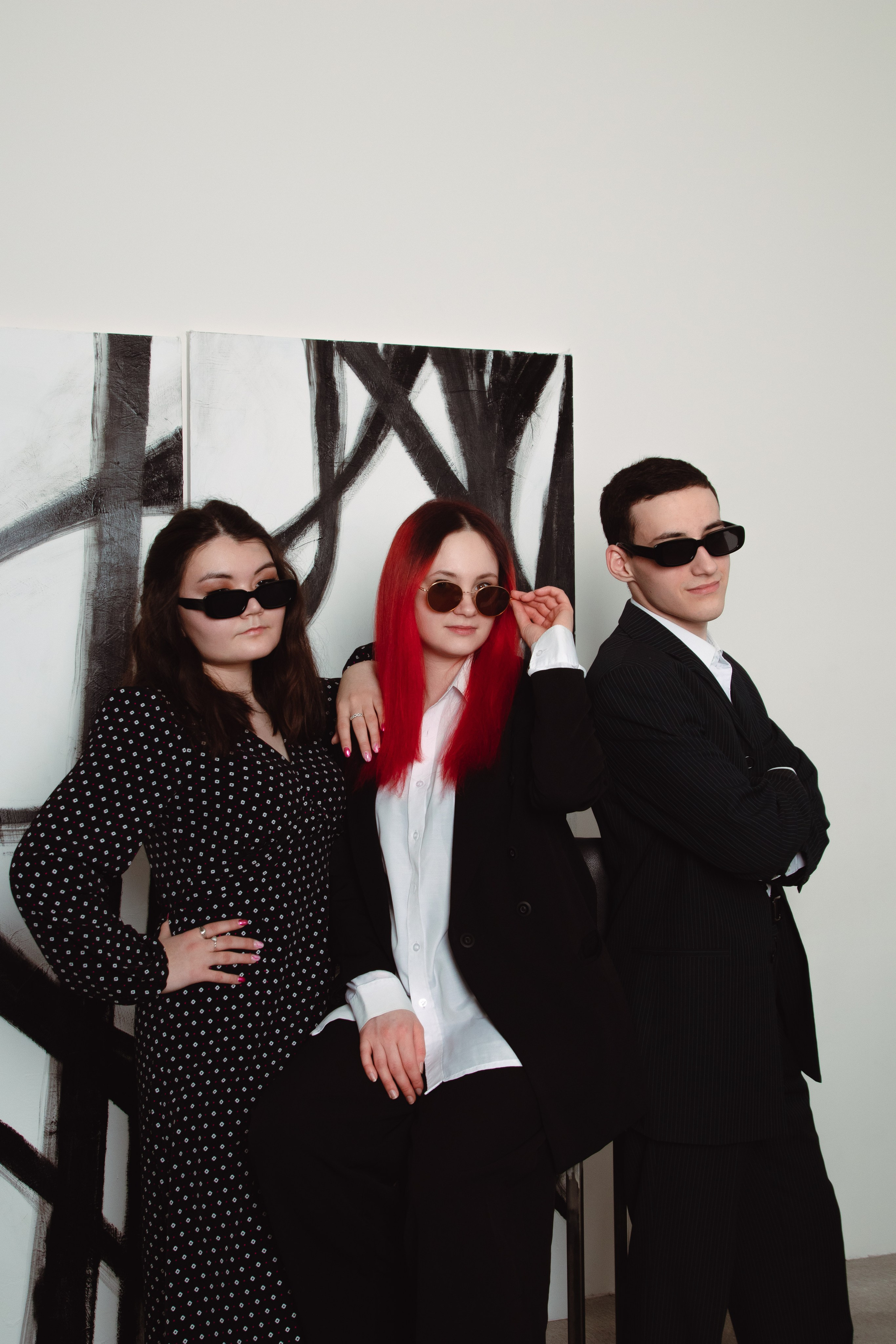 Семейная фотосессия в очках и черных классических костюмах на светлом фоне