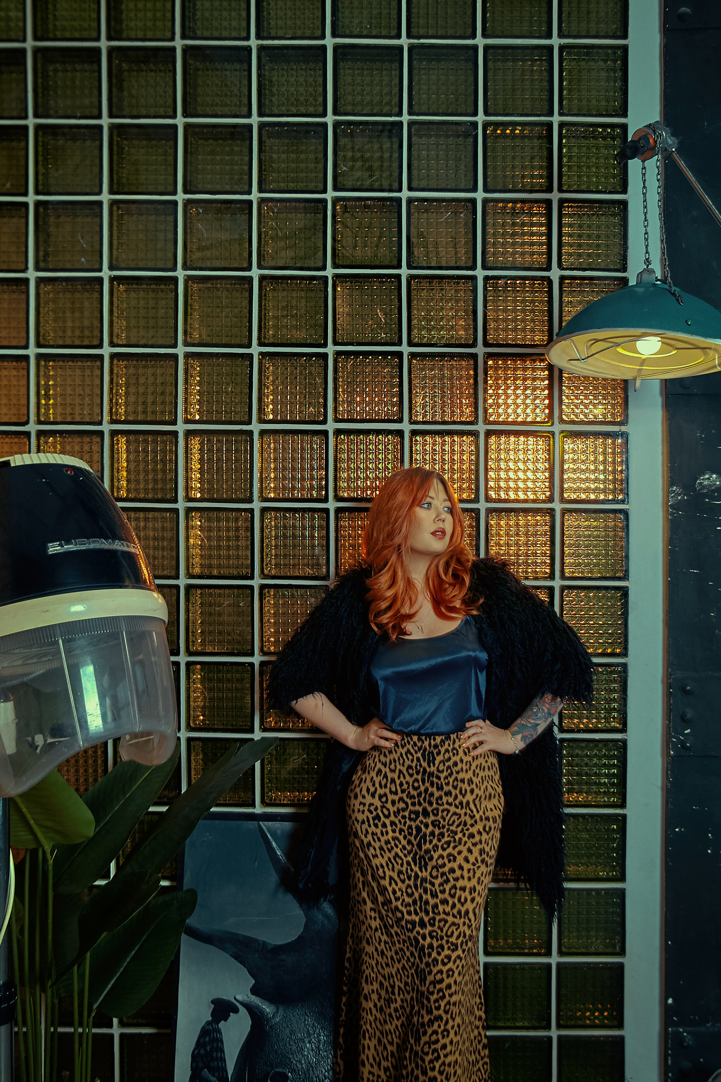 Рыжая девушка в ретро локации на фоне стеклоблоков